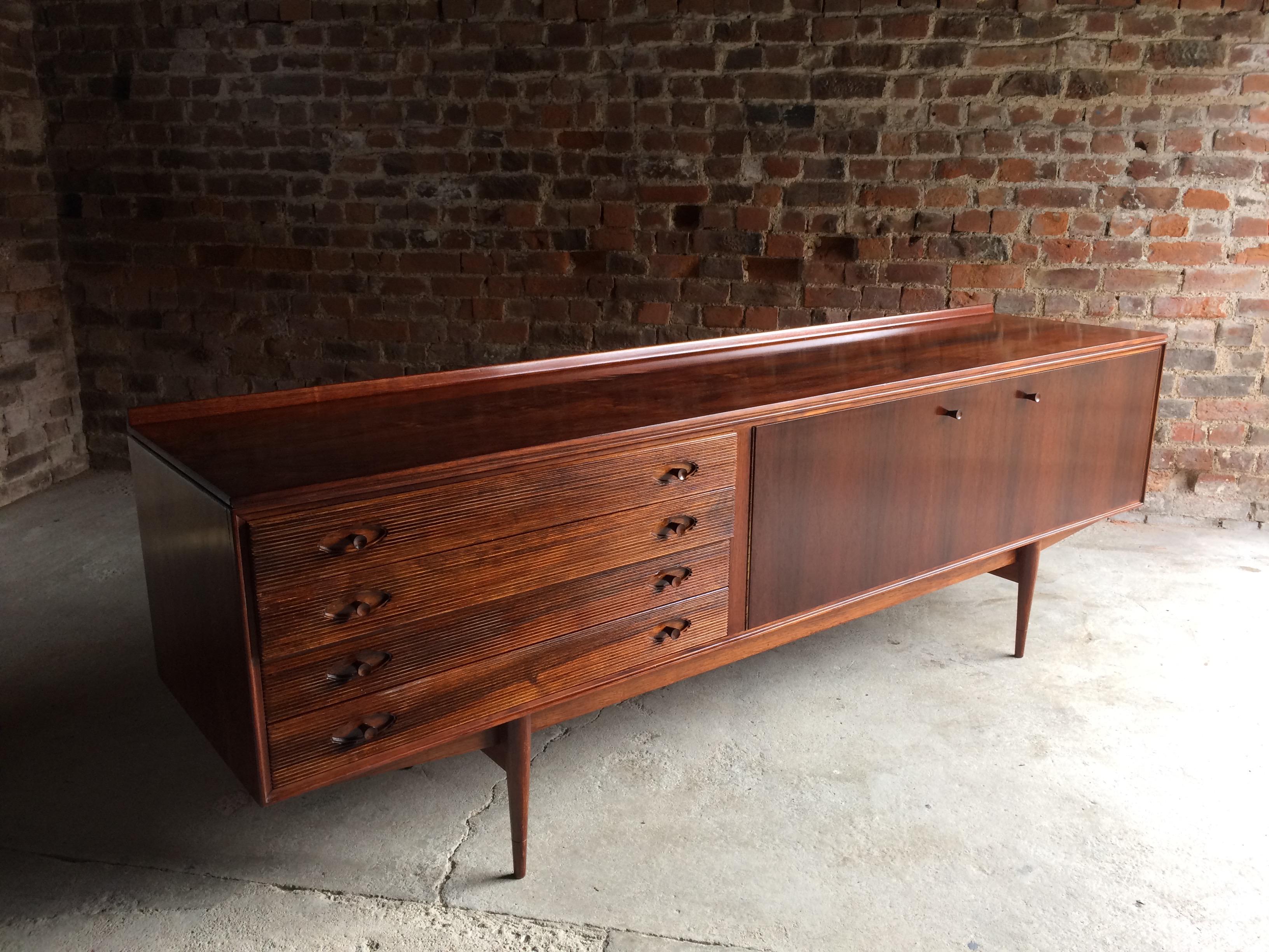 A beautiful mid century Hamilton Rosewood sideboard designed by Robert Heritage and manufactured by Archie Shine, England circa 1960, this elegant Danish style design with long rectangular top over four reeded drawers with two cupboards, having