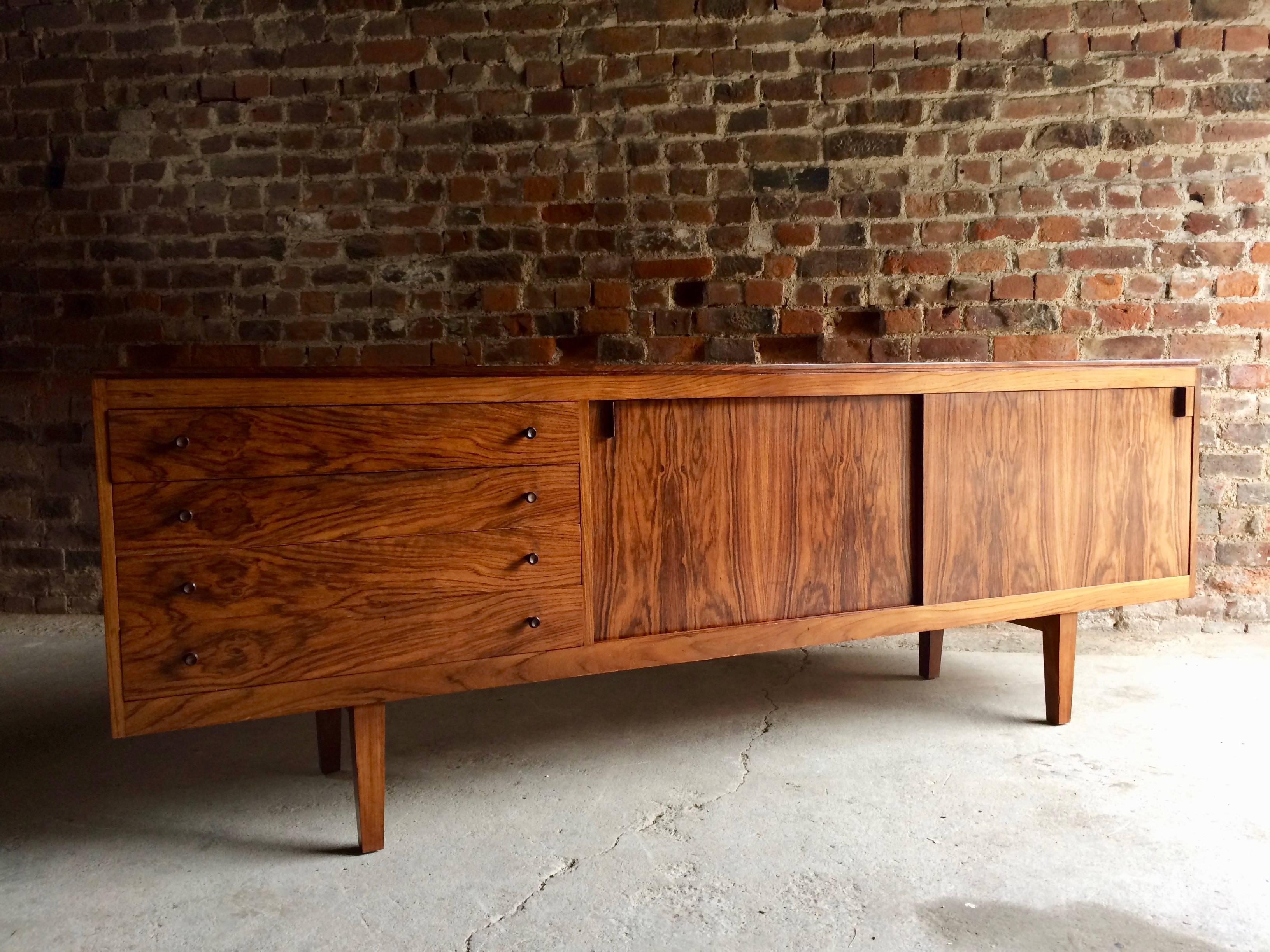 Magnificent midcentury Robert Heritage rosewood credenza sideboard designed for Archie Shine, circa 1960s, the long rectangular top over four drawers to the left side and two sliding cupboard doors to the right, raised on four tapered