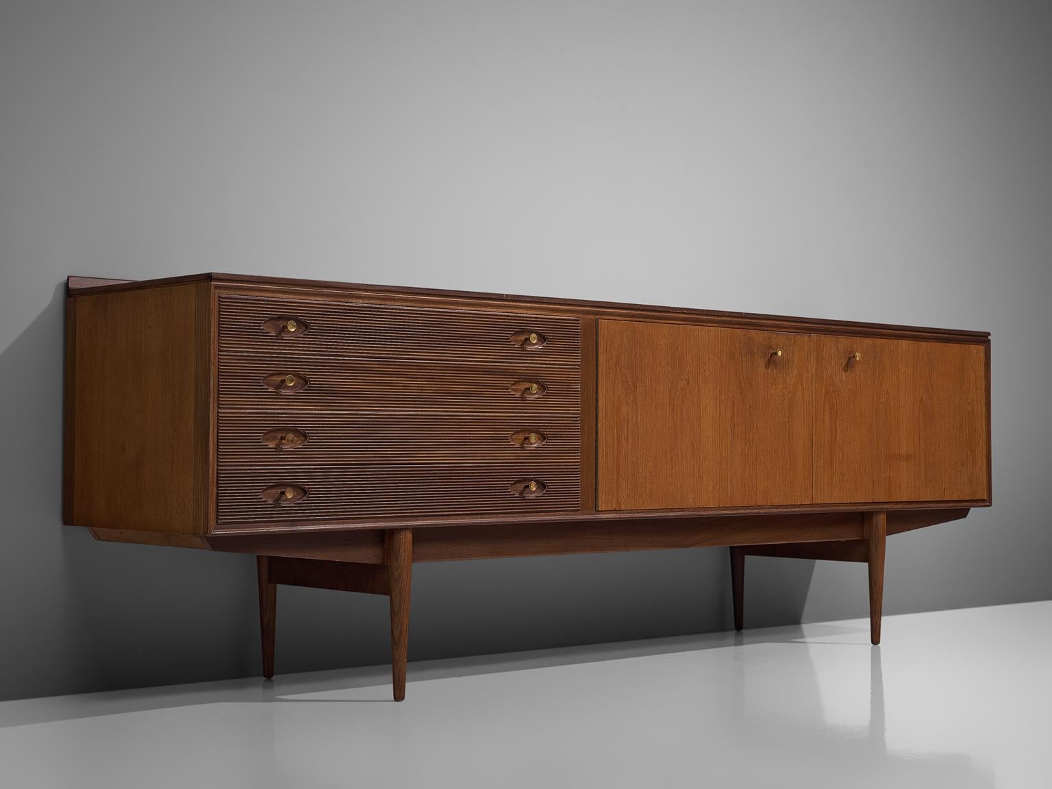 Robert Heritage for Archie Shine, sideboard, walnut, United Kingdom, 1960s 

This sideboard is equipped with a drawer section with 4 drawers and a large storage unit. The drawers are detailed with ridged fronts and wooden handles based on straight