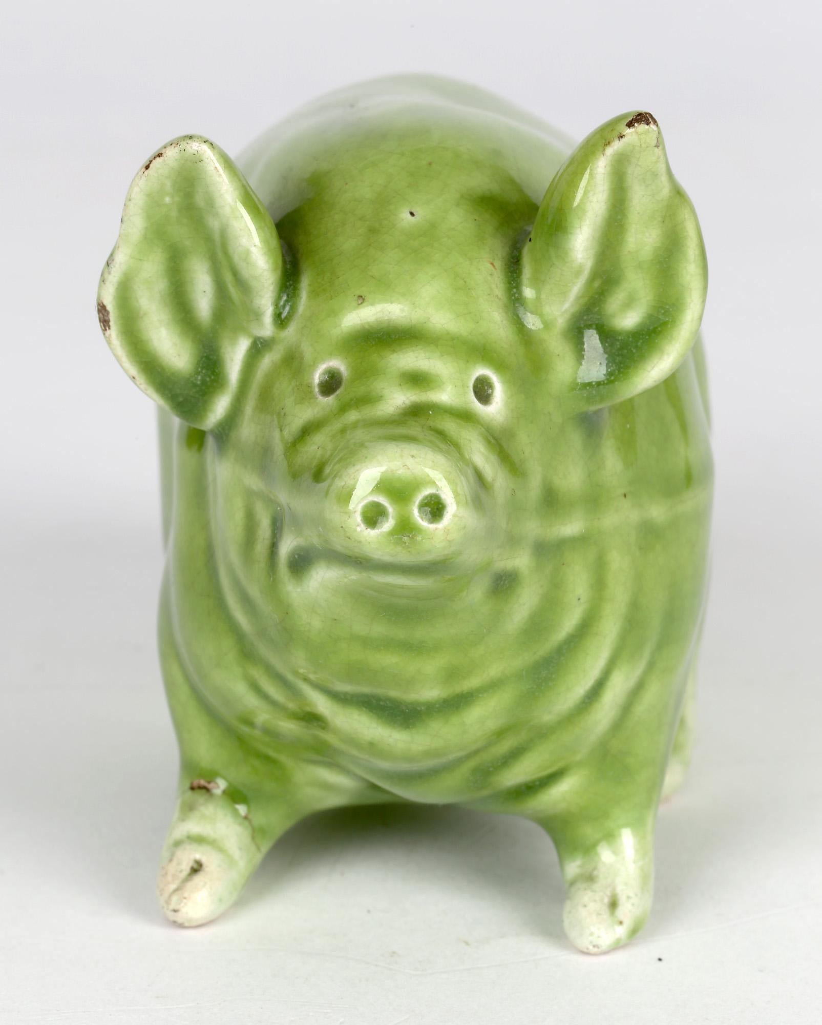 A delightful Scottish Wemyss Ware pottery pig decorated in green glazes made by Robert Heron & Son and dating from around 1900. The well potted earthenware figure stands raised on four short small legs with pig shaped body, raised ears, snout and