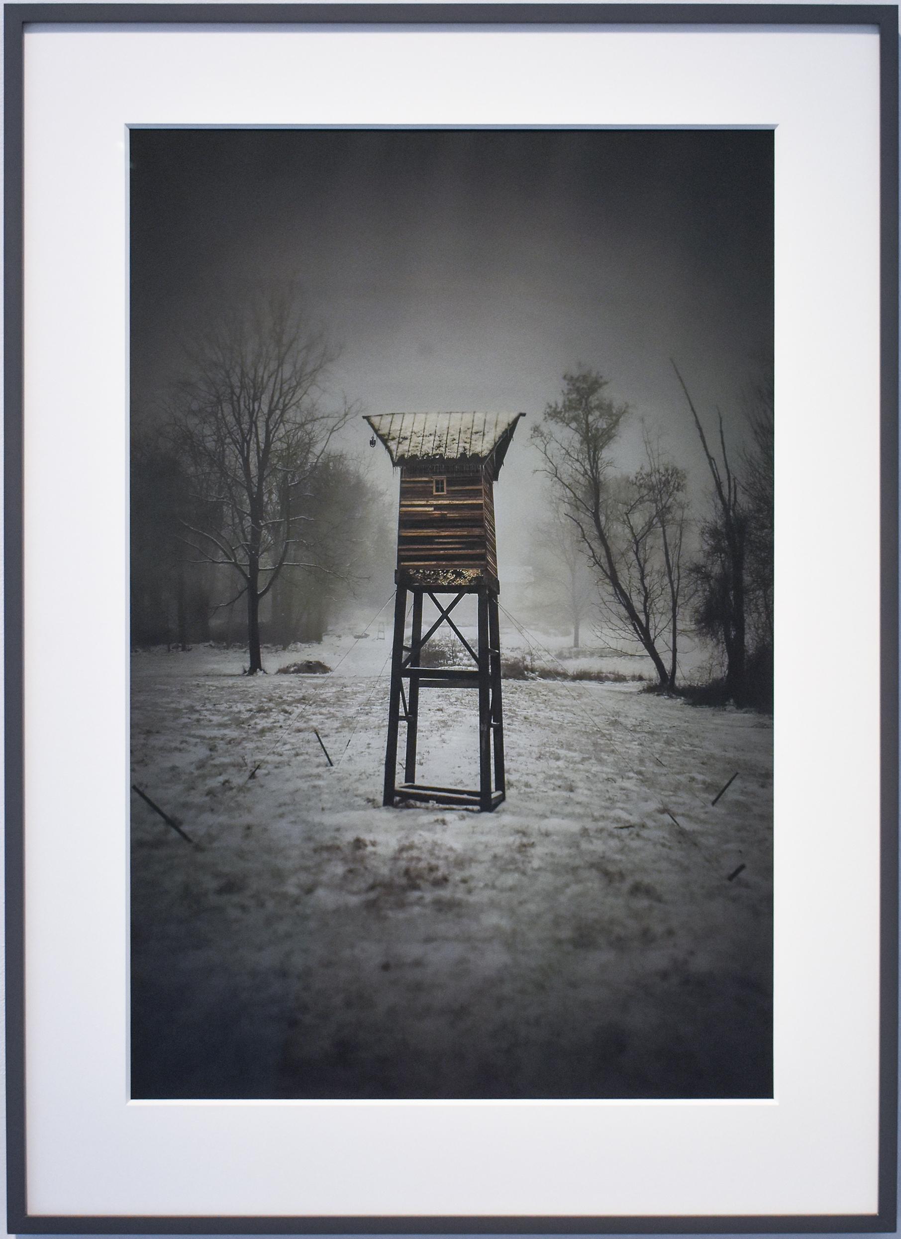 Black and white photograph with subtle color of a brown wooden structure in a winter landscape 
archival pigment print, edition of 10 
27 x 18 inches, 33 x 24 inches in dark grey painted wood frame with 8-ply mat and non-glare glass

This