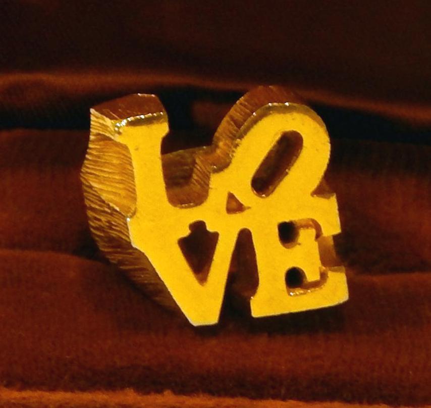 Vintage Robert Indiana Gold-tone Pop Art Love ring with textured side detailing.
Made famous in the 1970s. Gold-tone on brass. Size 6 to 6.5, circa 1970.
The face measures 0.75” x 0.75”. Great vintage condition, looks unworn.
Velvet box included.