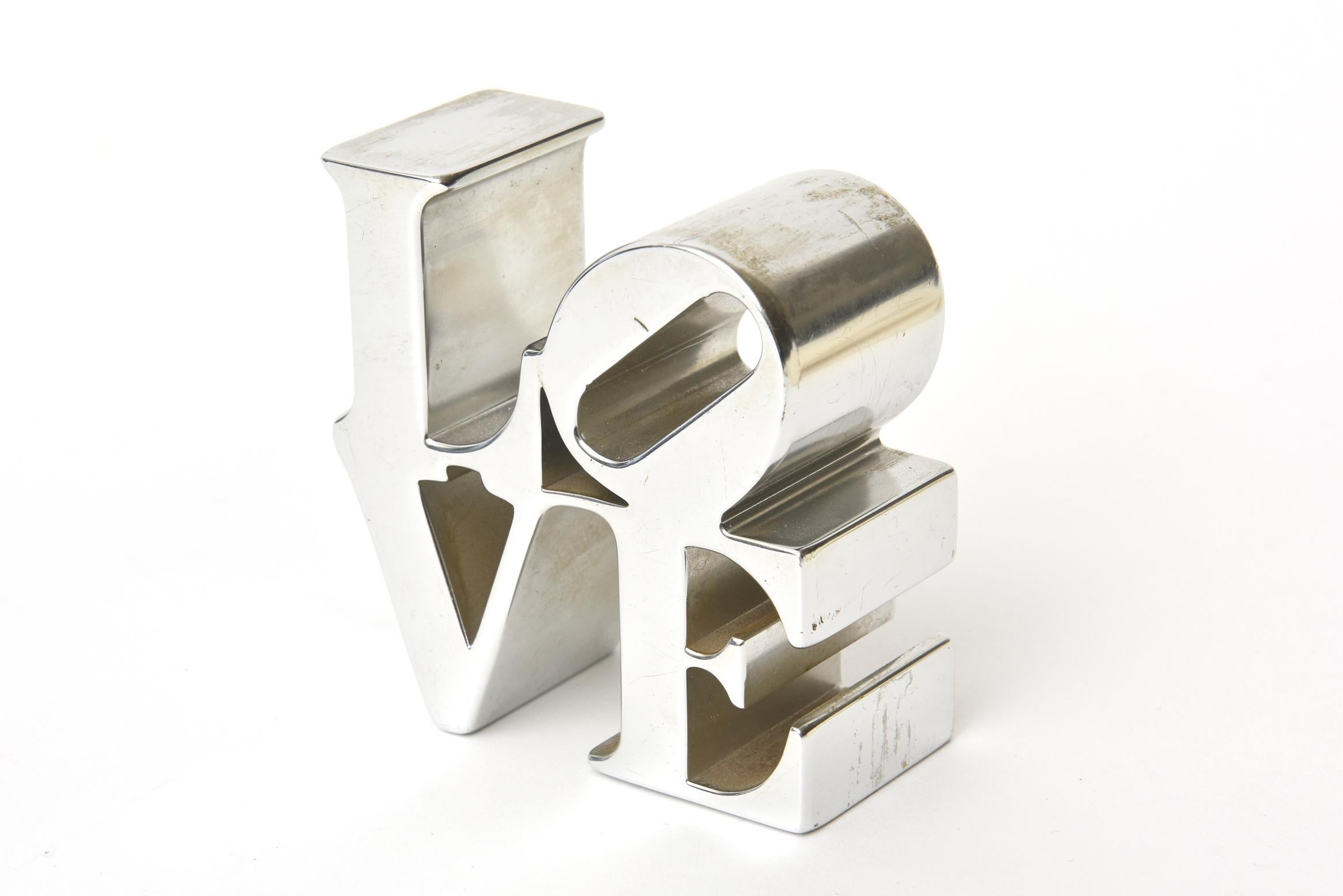 This iconic love chrome-plated aluminum Robert Indiana paperweight /sculpture is from the 1970s. The artist's original love painting in the 1970s put him on the map of highly collectable artists. It says it all. In this world of non communication