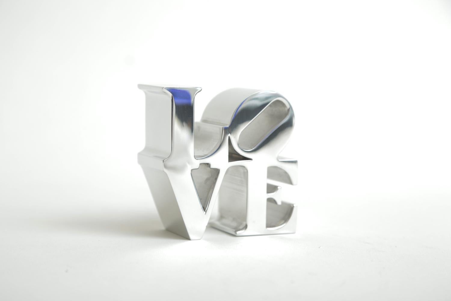This authentic Robert Indiana chrome LOVE paperweight sculpture is vintage from the 1970s. This will make a great desk accessory. These were at one time sold in museum stores at that time such as MOMA and various other high end museum shops and
