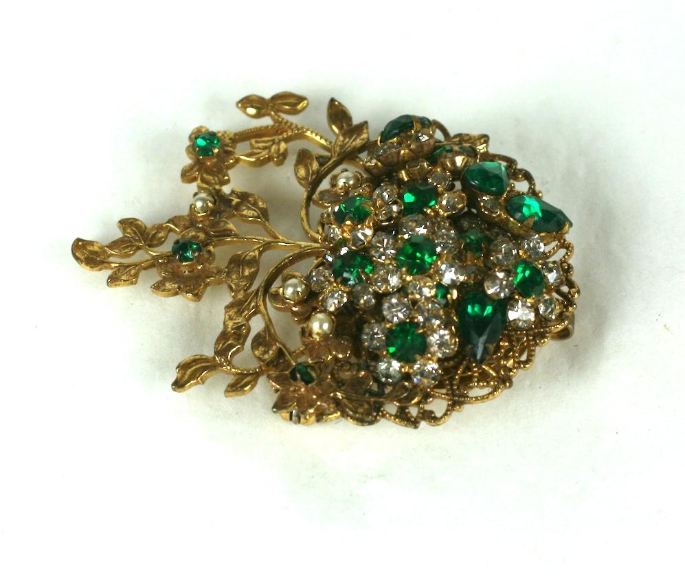 Robert Jeweled Emerald Crystal Heart Brooch from the 1940's. Handwired emerald and clear crystal stones are set with faux pearls in a heart formed motif with leafy vines. Can be worn as pendant as well in opposite direction.
1940's USA.  Excellent