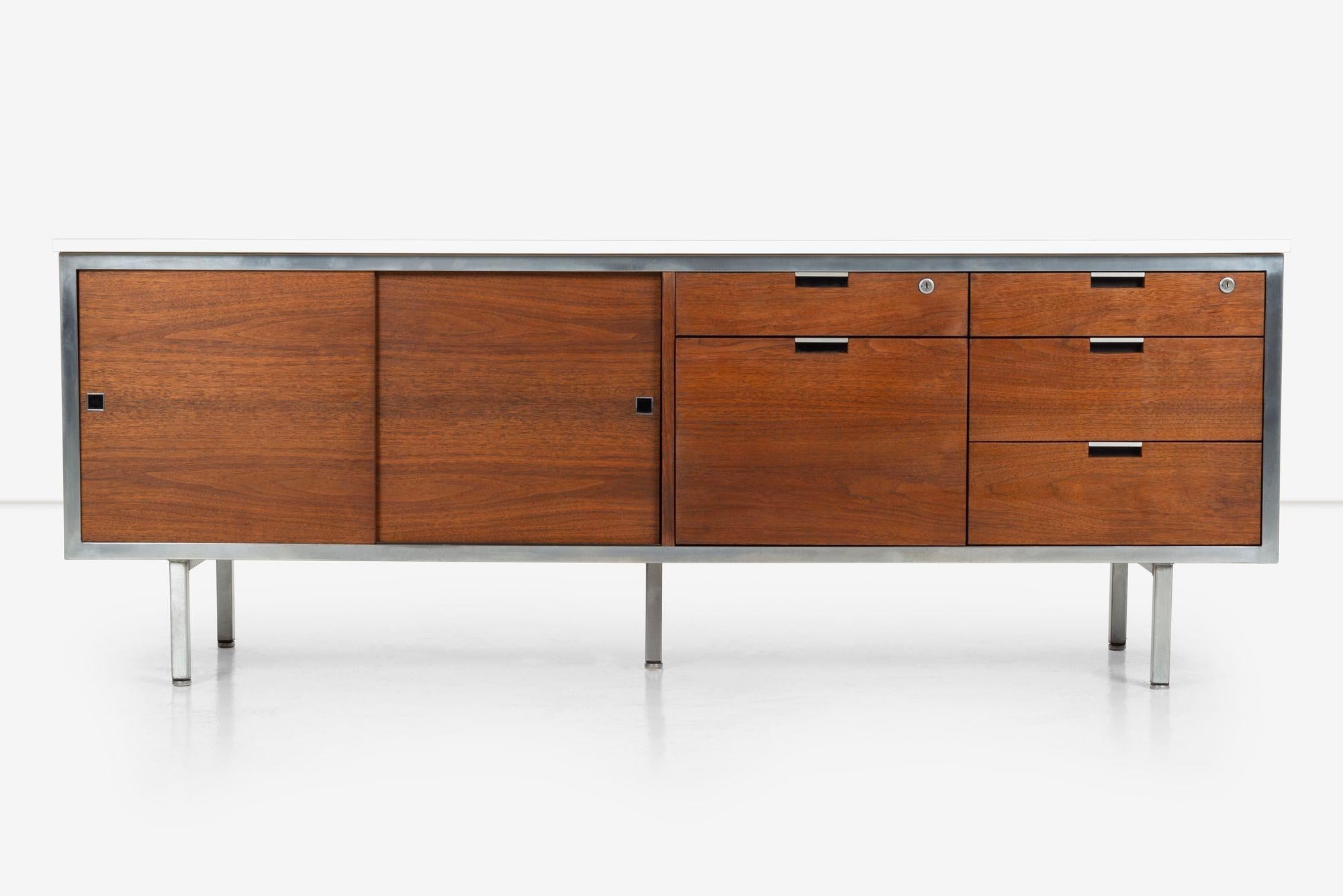 Robert John Credenza, five drawers 2 pencil drawers with locks, one file drawer with notch pulls, sliding doors with removable adjustable shelf.
Walnut veneer with white laminate top and steel legs.
(Lable inside drawer Robert John).