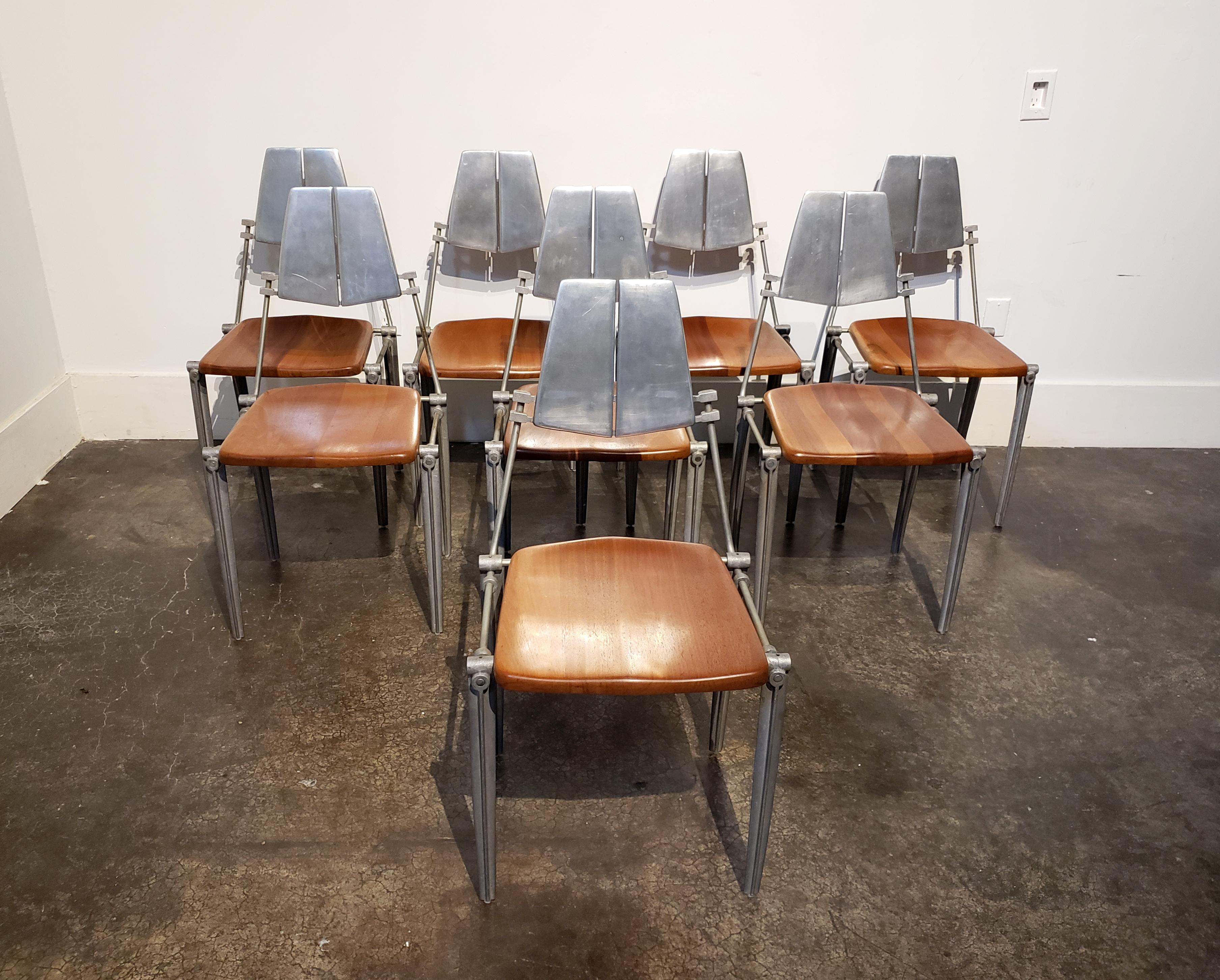 Chic, cast aluminum dining chairs with warm maple wood seats designed by Los Angeles designer and manufacturer, Robert Josten in the 1980s. Classic Josten styling with elegant curved legs and exaggerated industrial fittings. Seat backs are polished