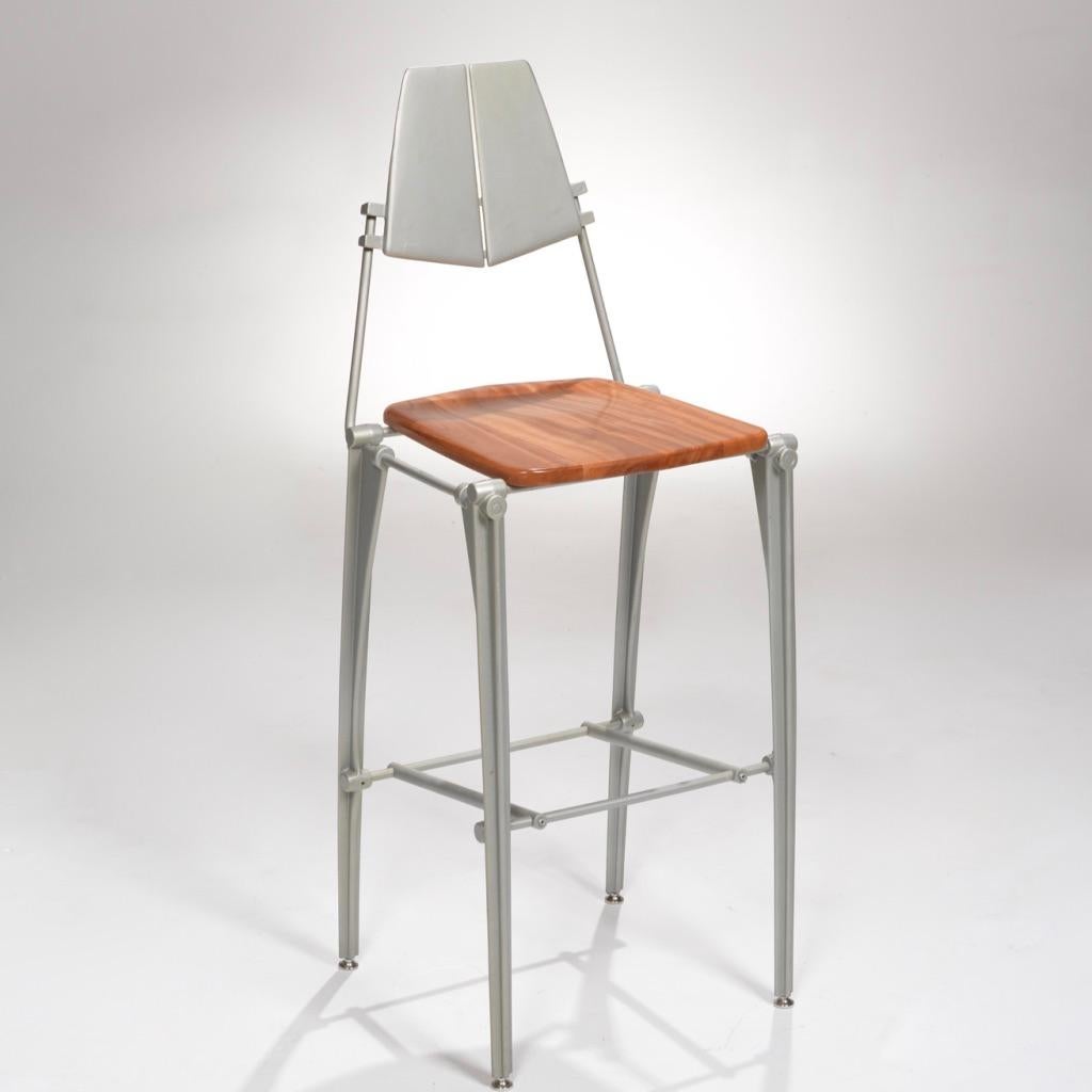 Designed by Robert Josten, these cast aluminum bar stools feature sculpted aluminum backs or frames along with a comfortably molded wooden seat.