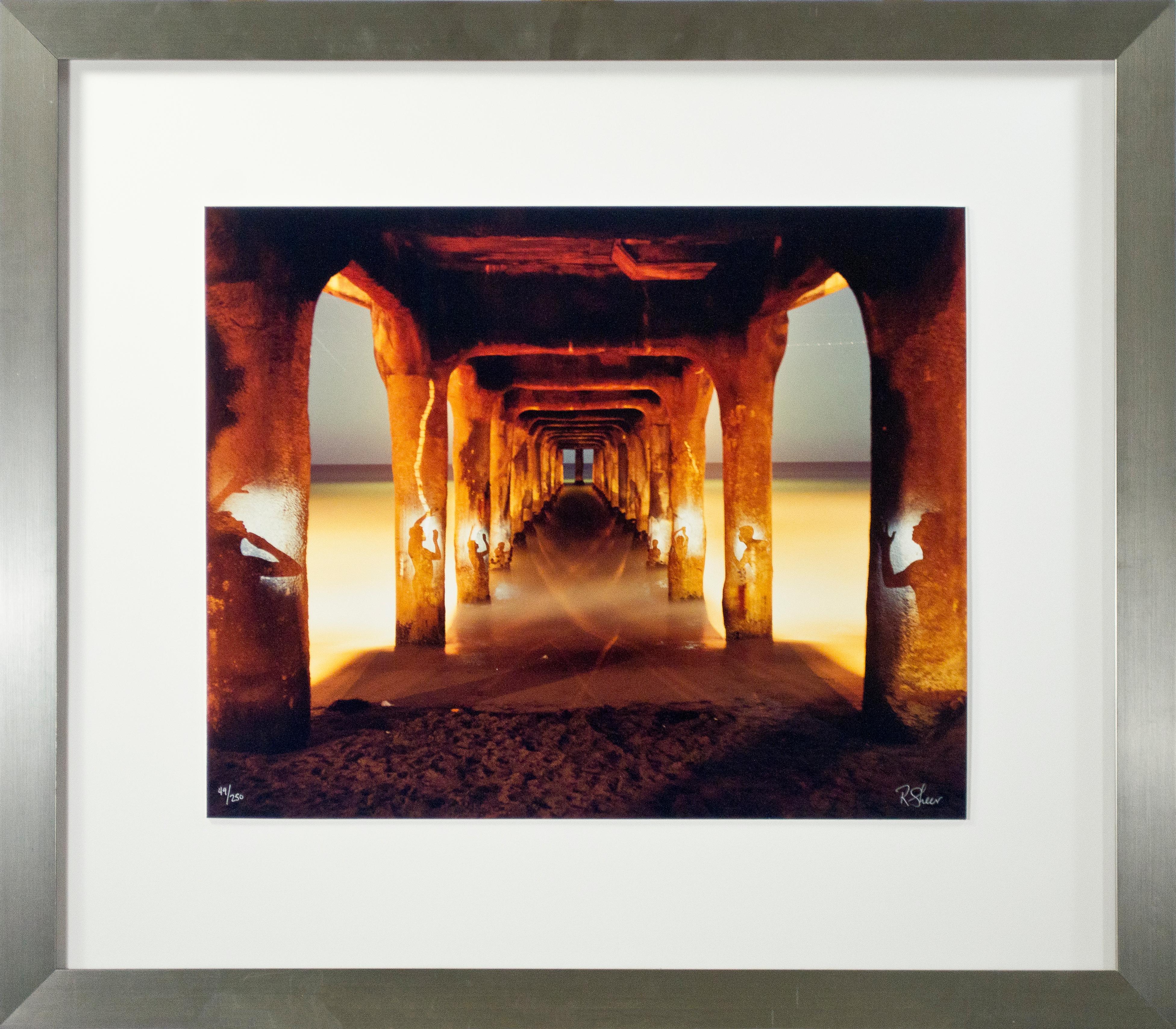 'Under the Manhattan Beach Pier No. 2' exemplifies the long-exposure photography of Robert Kawika Sheer. The artist signed this piece in the lower right and editioned it in the lower left. Edition: 49/250. Sheer has the camera looking down the long