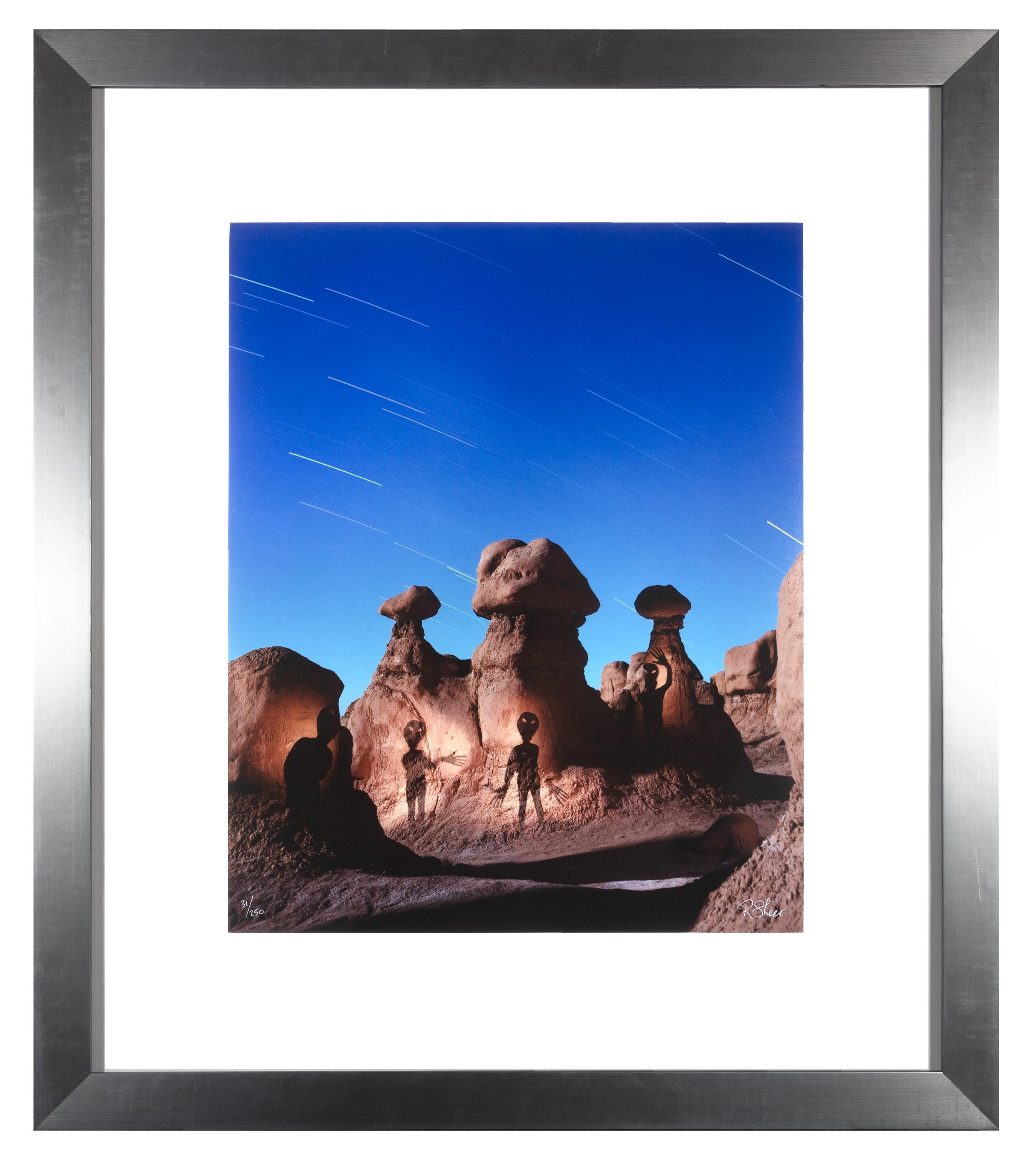 "Aliens at Goblin Valley," is an original fine-art performance photograph by Robert Kawika Sheer. The artist signed the piece in the lower right and editioned it in the lower left. Edition 31/250. The piece depicts a desert with mushroom-like rock