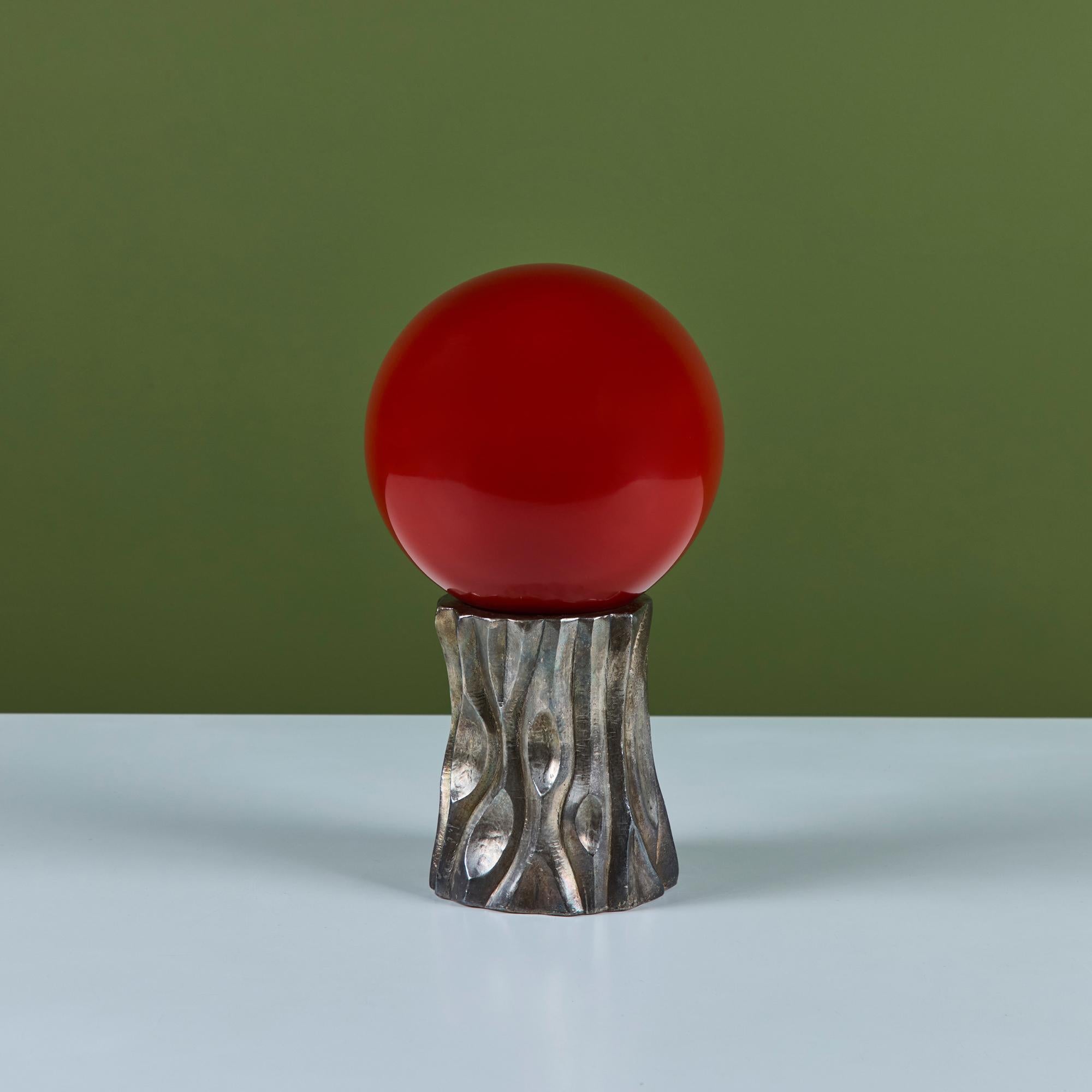 Hand blown glass and metal sculpture by Robert Kuo, c.2000s, USA. The globe was produced using the peking glass method which originated in China. The red colored glass is blown into its form and then layered with more and more glass until the piece