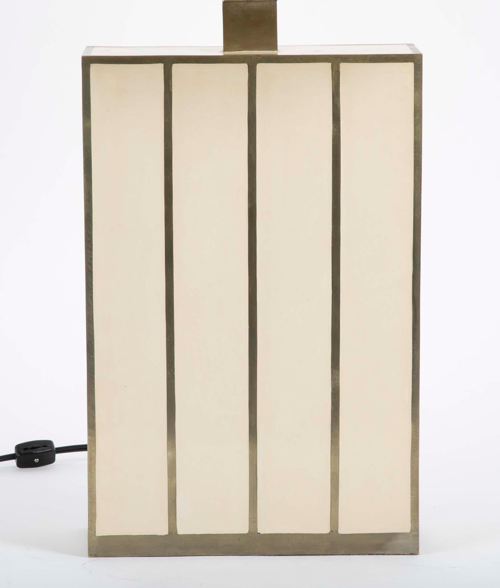 A rectangular form Robert Kuo table lamp with ivory colored panels inside brass banding. With new shade.