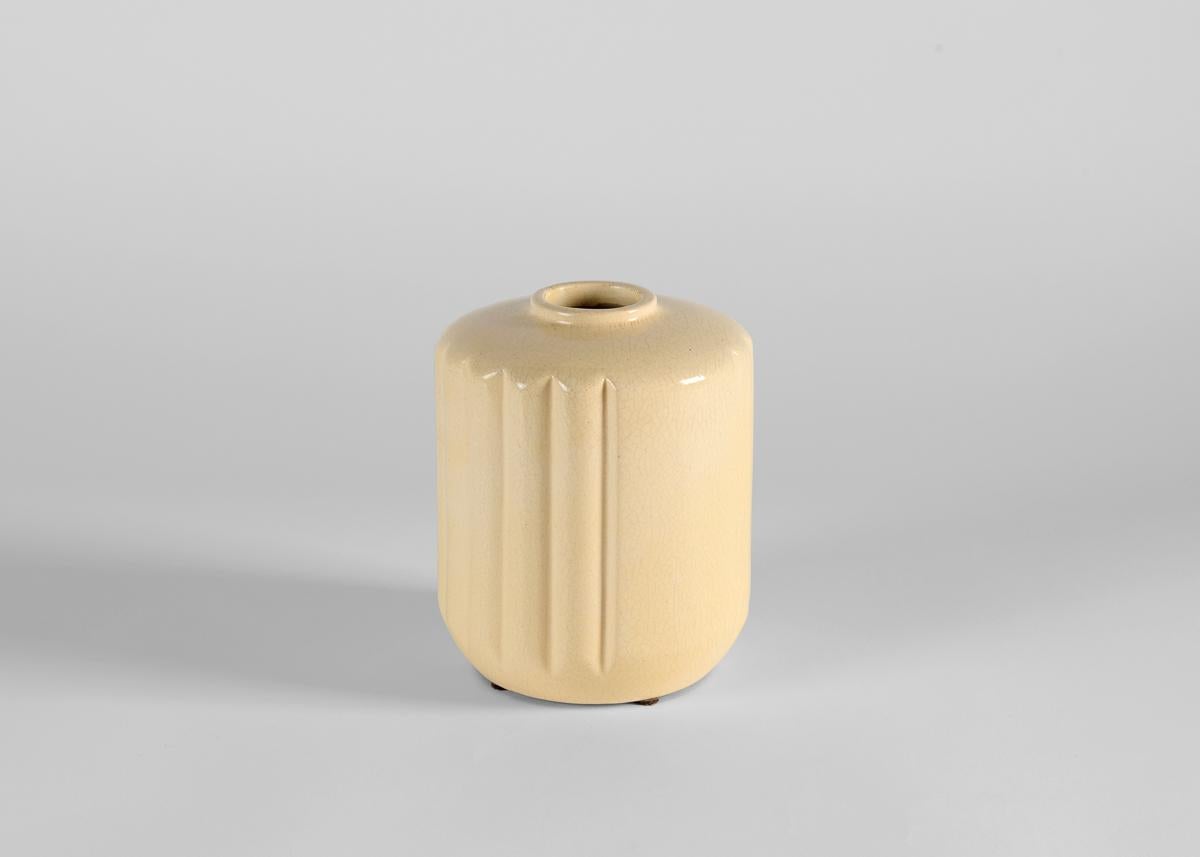 Un piccolo vaso a bocca stretta e a coste verticali con un'incantevole smaltatura color crema.