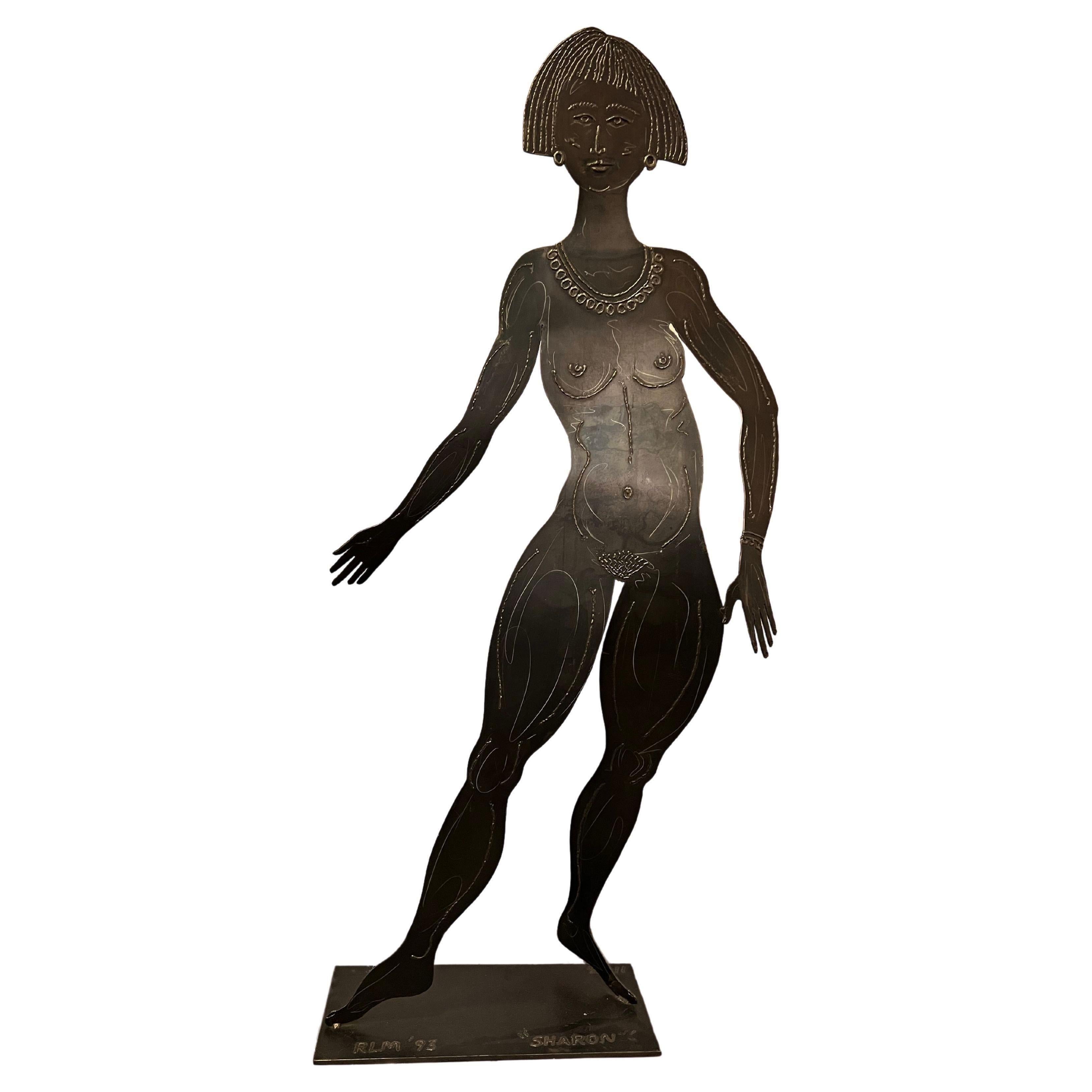 Vor dem Geschäft von Robert Lee Morris in Beverly Hills stand 1993 diese einzigartige, lebensgroße Messingskulptur einer nackten Frau mit Bobschnitt, die nur mit luxuriösem Schmuck bekleidet war. Die Skulptur mit dem Namen "Sharon" spiegelt Morris'