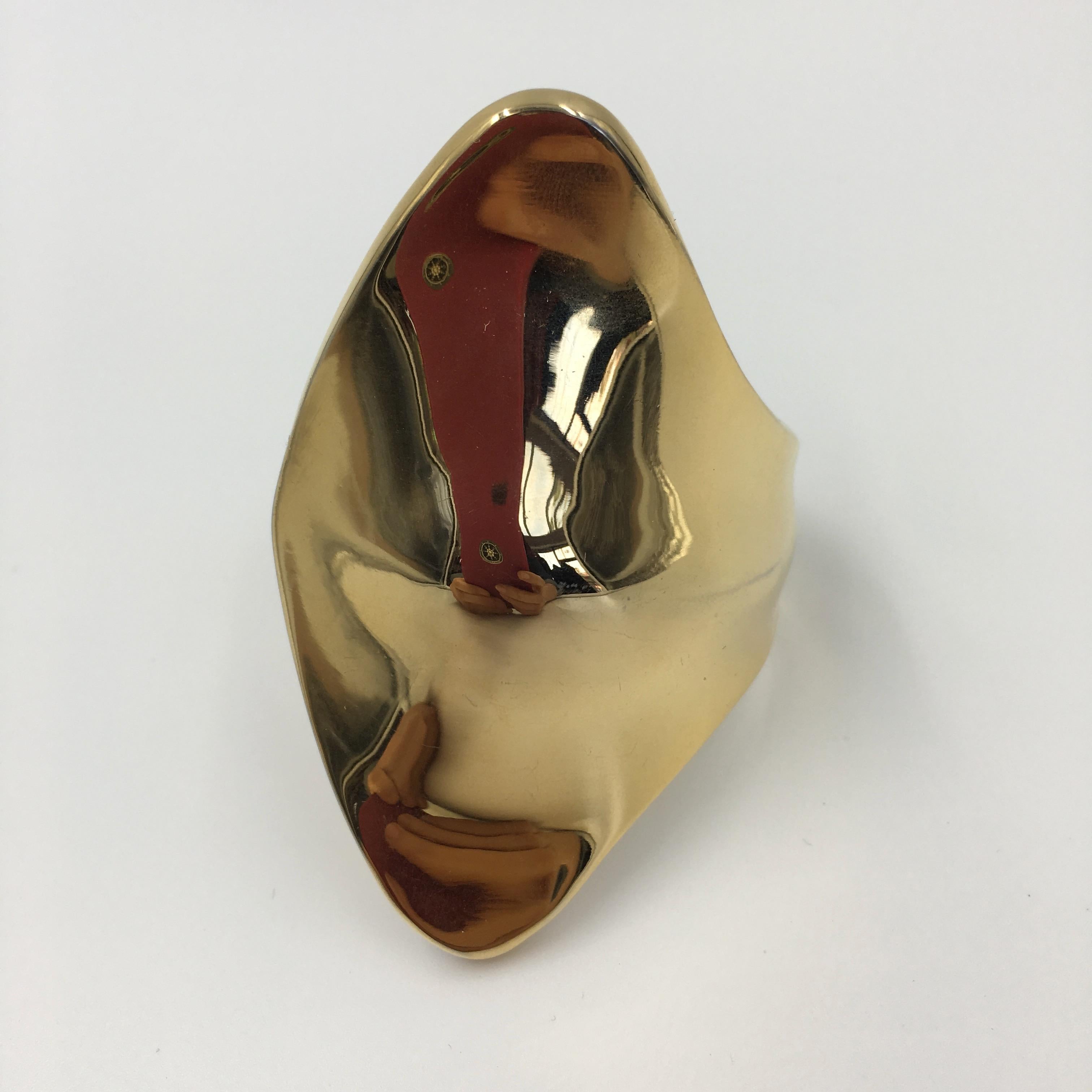 Superbe bracelet manchette plaqué or 24k. Conçu pour s'adapter à l'os du poignet. Voir la photo. 
Nous dirions qu'il convient à un poignet de taille petite/moyenne. Logo estampillé à l'intérieur.
Vintage, en excellent état. Pas de rayures.