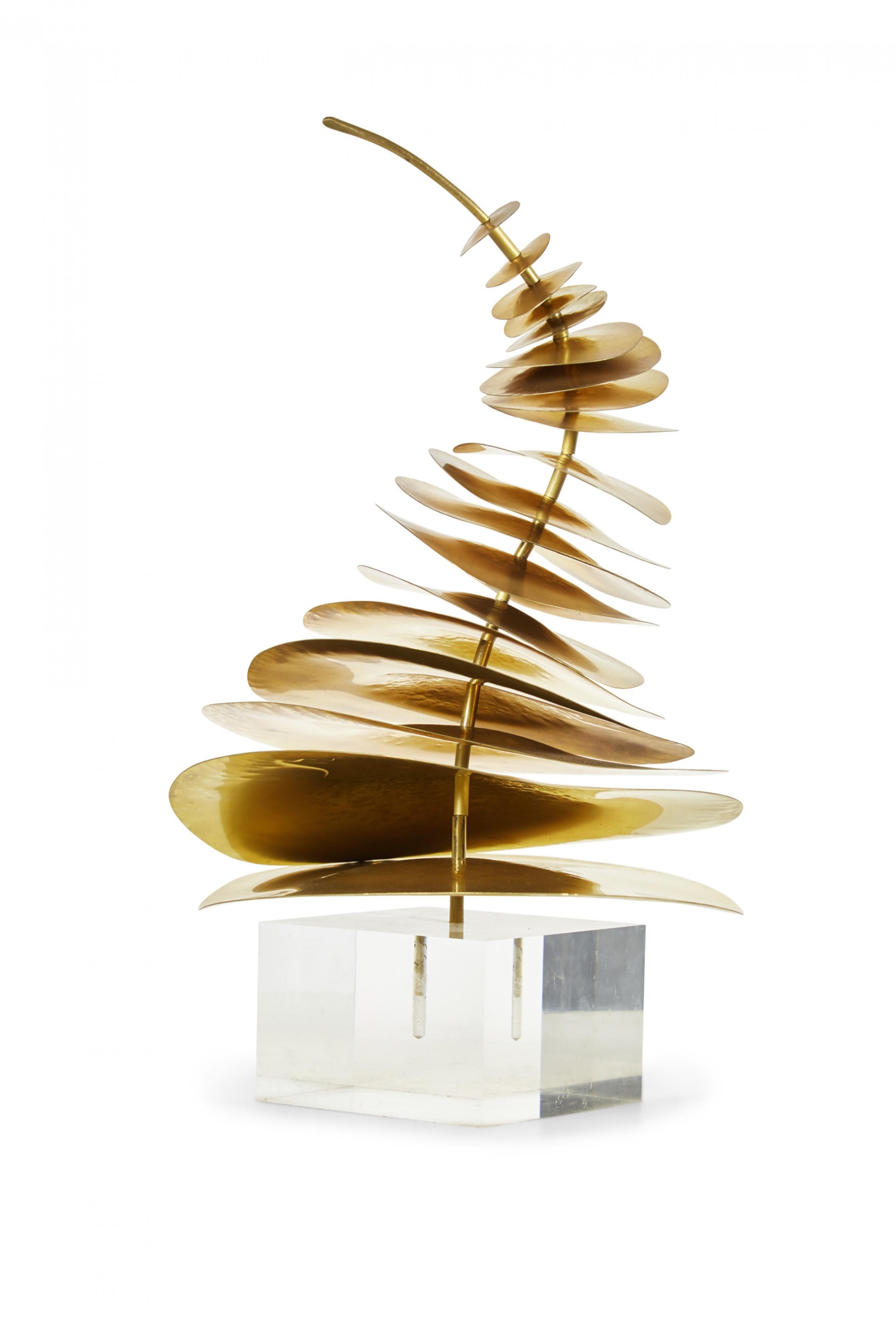 Scultura astratta contemporanea composta da dischi di ottone di dimensioni graduate montati verticalmente su un'asta di ottone ricurva ancorata a una base di lucite, intitolata 