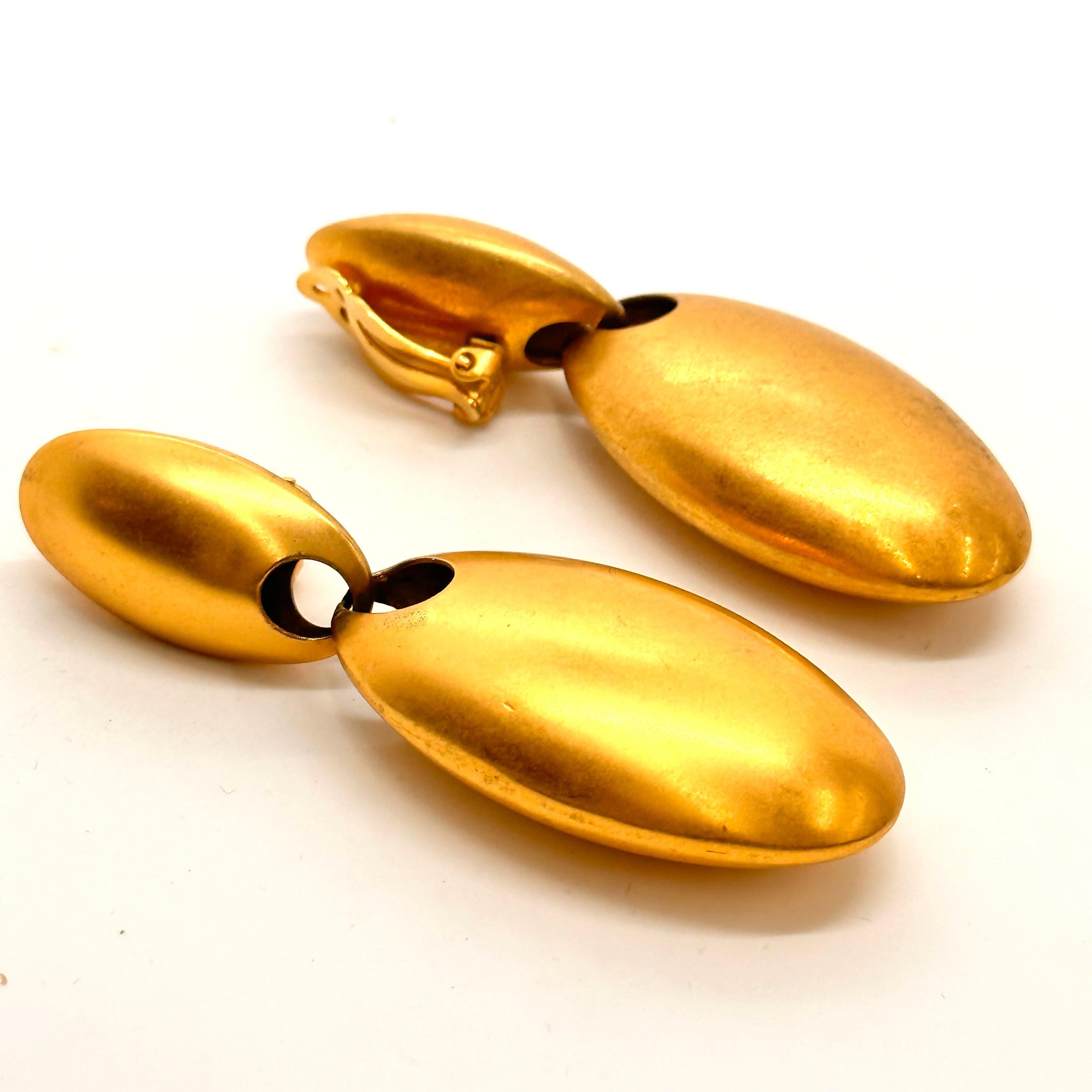 In 1989 Robert Lee Morris created a collection of matte gold plated brass jewelry for Donna Karan all in the theme of egg forms. These voluptuous clip earrings are constructed of two hollow elongated egg forms that hang perpendicular to one another.