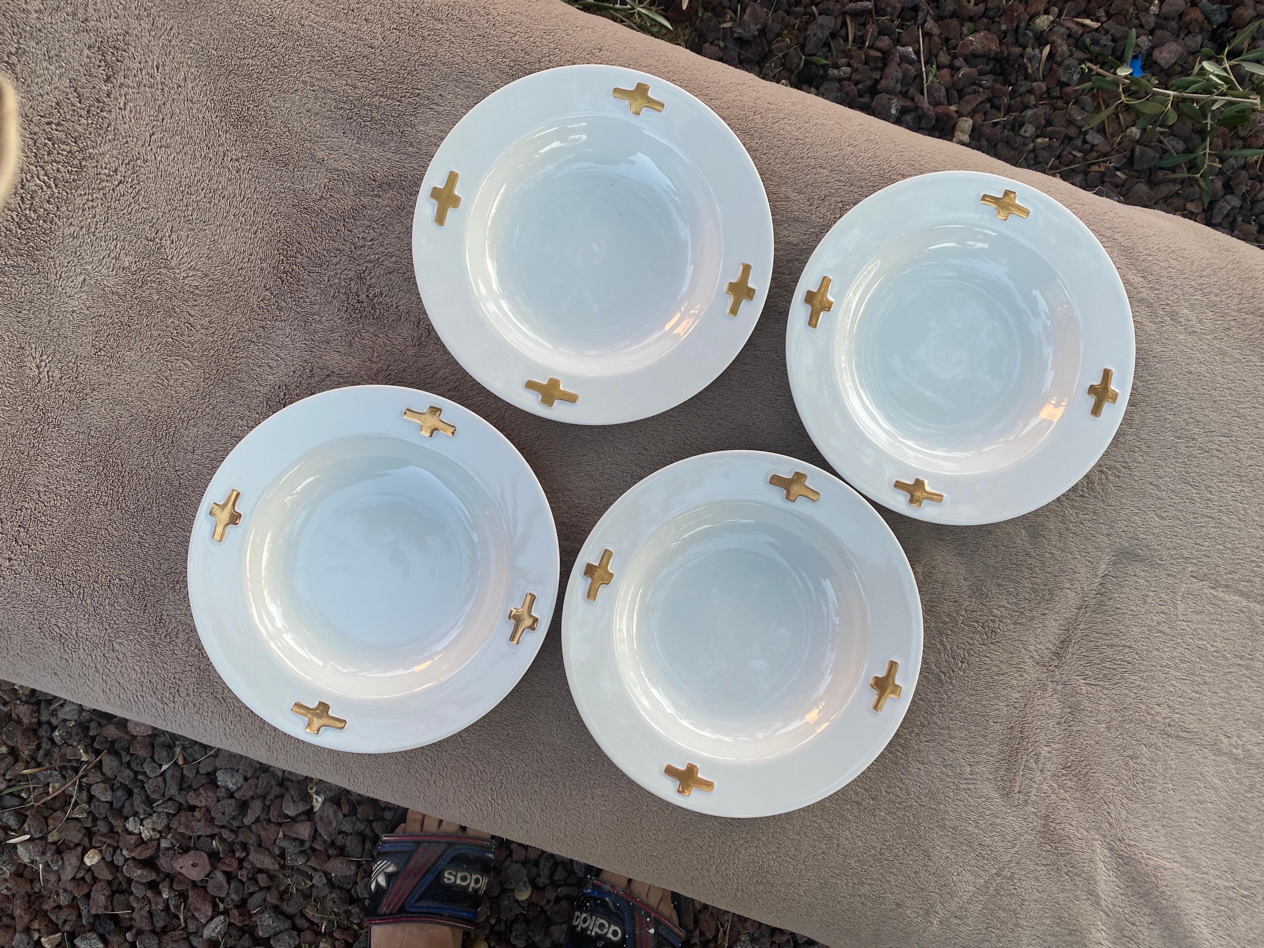 This set of dinnerware bowls were designed by the legendary jewelry and fine art designer, Robert Lee Morris for Swid Powell. The pattern name is called Camelot and is a chic, modern design of shiny white with 4 metallic gold crosses. It is almost