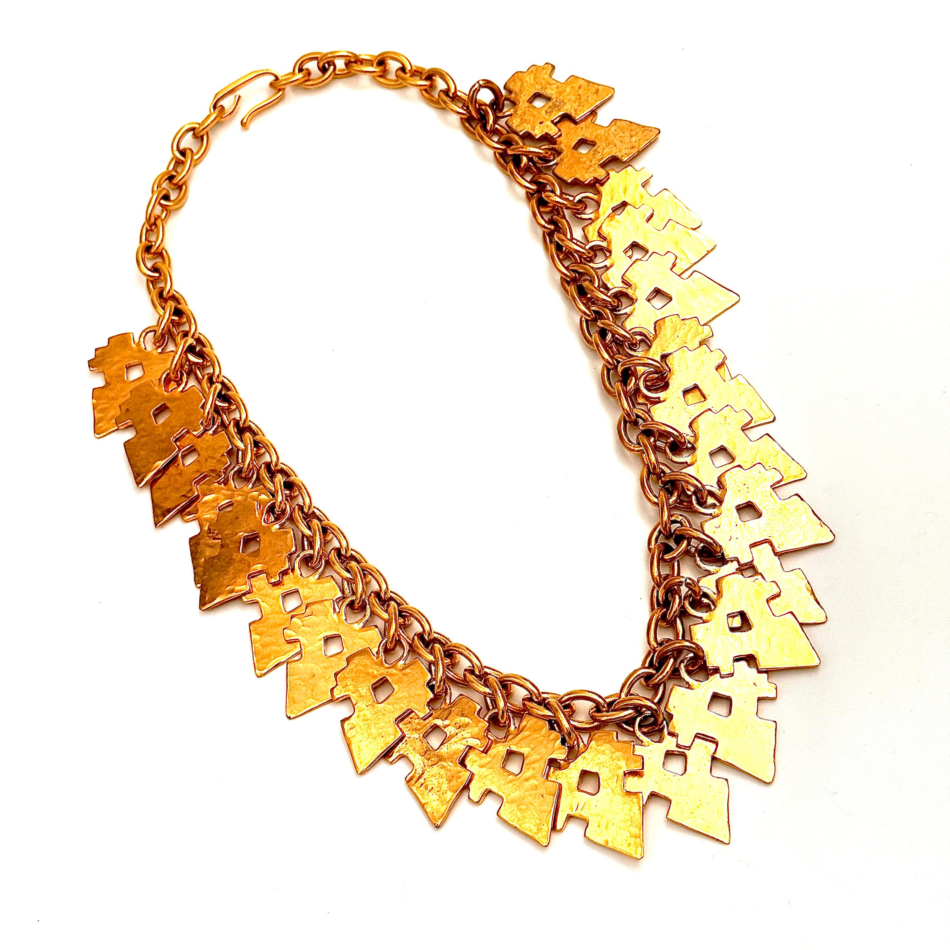 Creada en 1983, la forma clave de esta pieza es una gota plana pero martillada en forma de punta de flecha. La forma sensual en que las numerosas piezas de flecos planos y brillantes se superponen y se agitan de un lado a otro hace que este collar