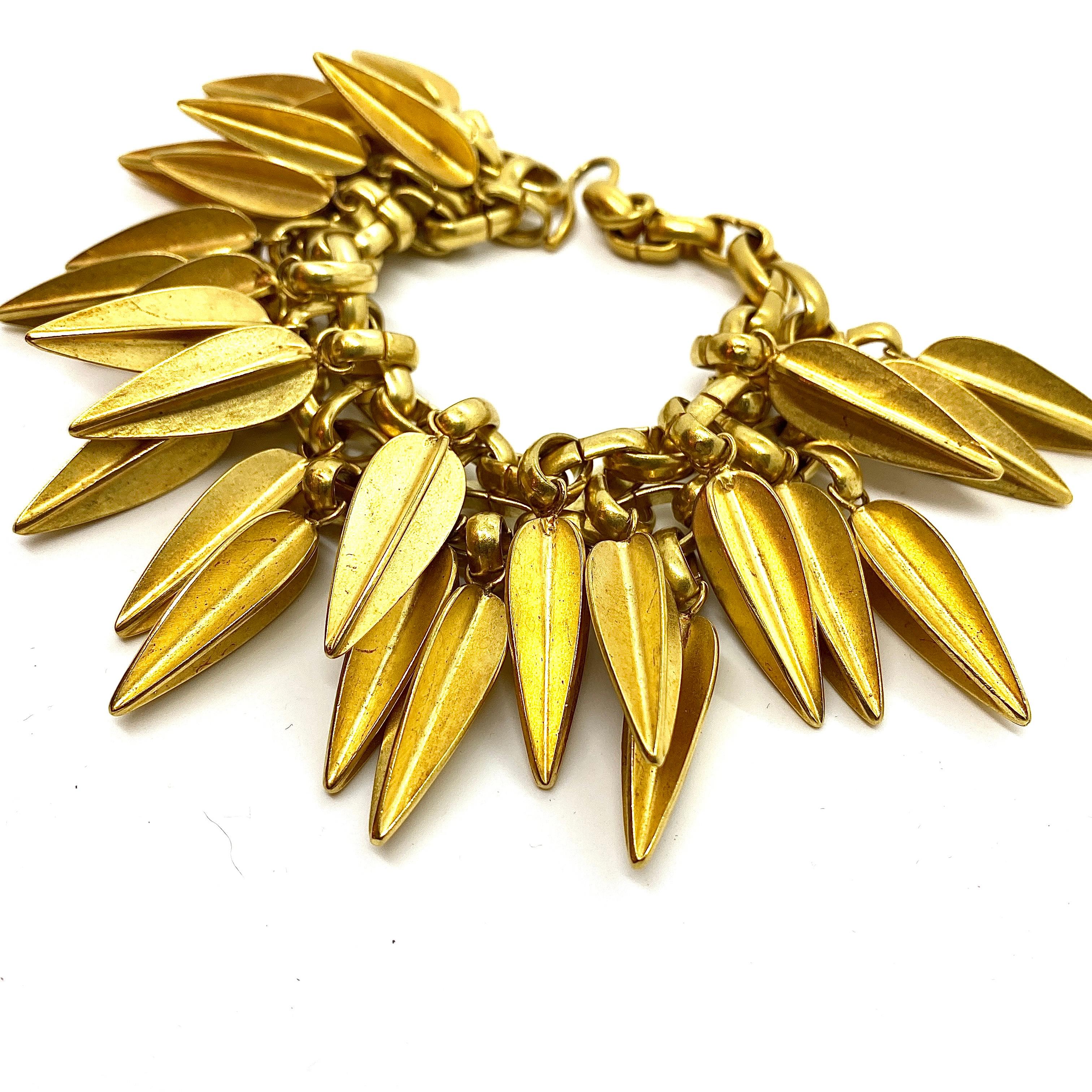 This multi row linked bracelet features gutsy dart pendants in various sizes, lush rich 24k gold plated brass forms that hang like clusters of exotic fruit. The Dart form was taken from the playing darts feather arrangement, and an entire Dart