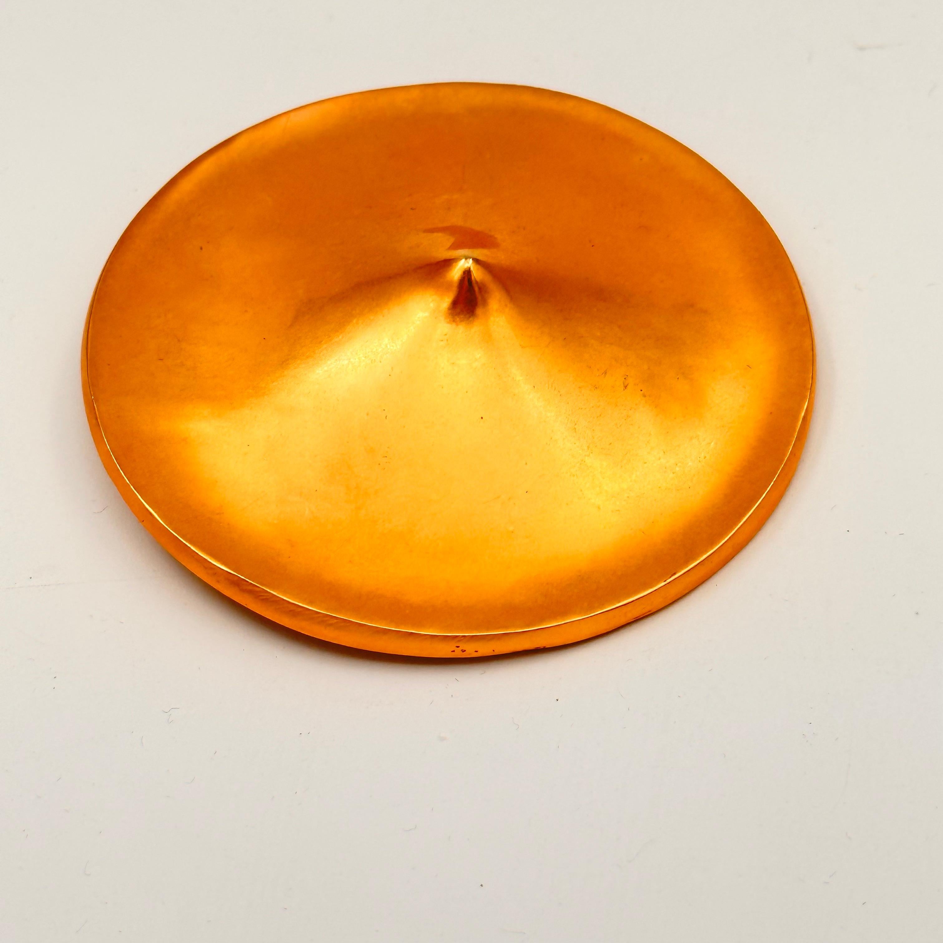 This very simple but strong shape, called a Gong, is gold plated brass, and is 3 inches diameter, a nice size for wearing on a jacket or coat. The way the disc comes to a point, like a classic Coolie hat, is subtle but distinctive. Created in the