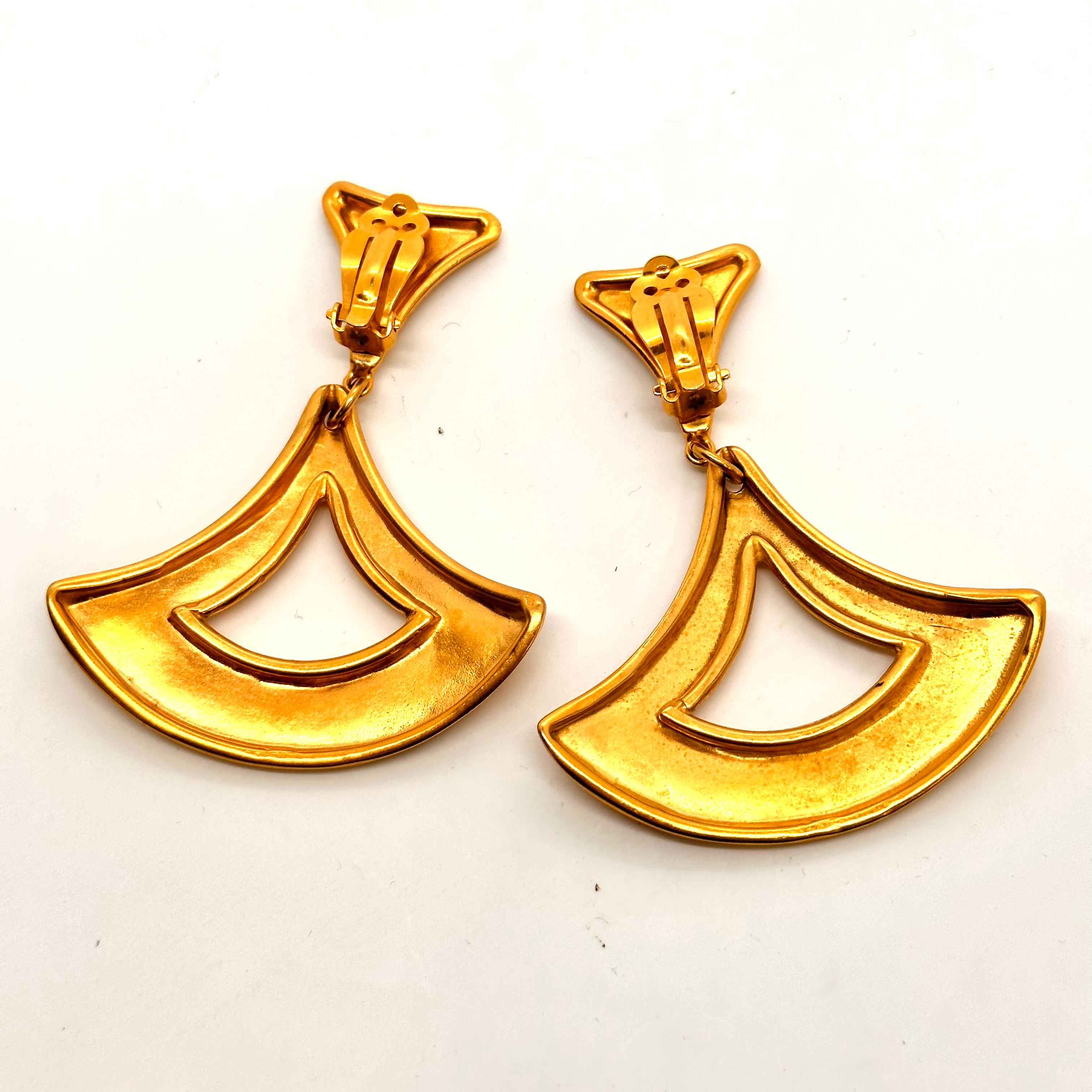 Bold Gold was the massive trend that Robert Lee Morris started in the 1980's and these bold swinging earrings are proof of that. 
A concave triangular top supports a wide curving triangular arc with a big opening. the positive/negative space