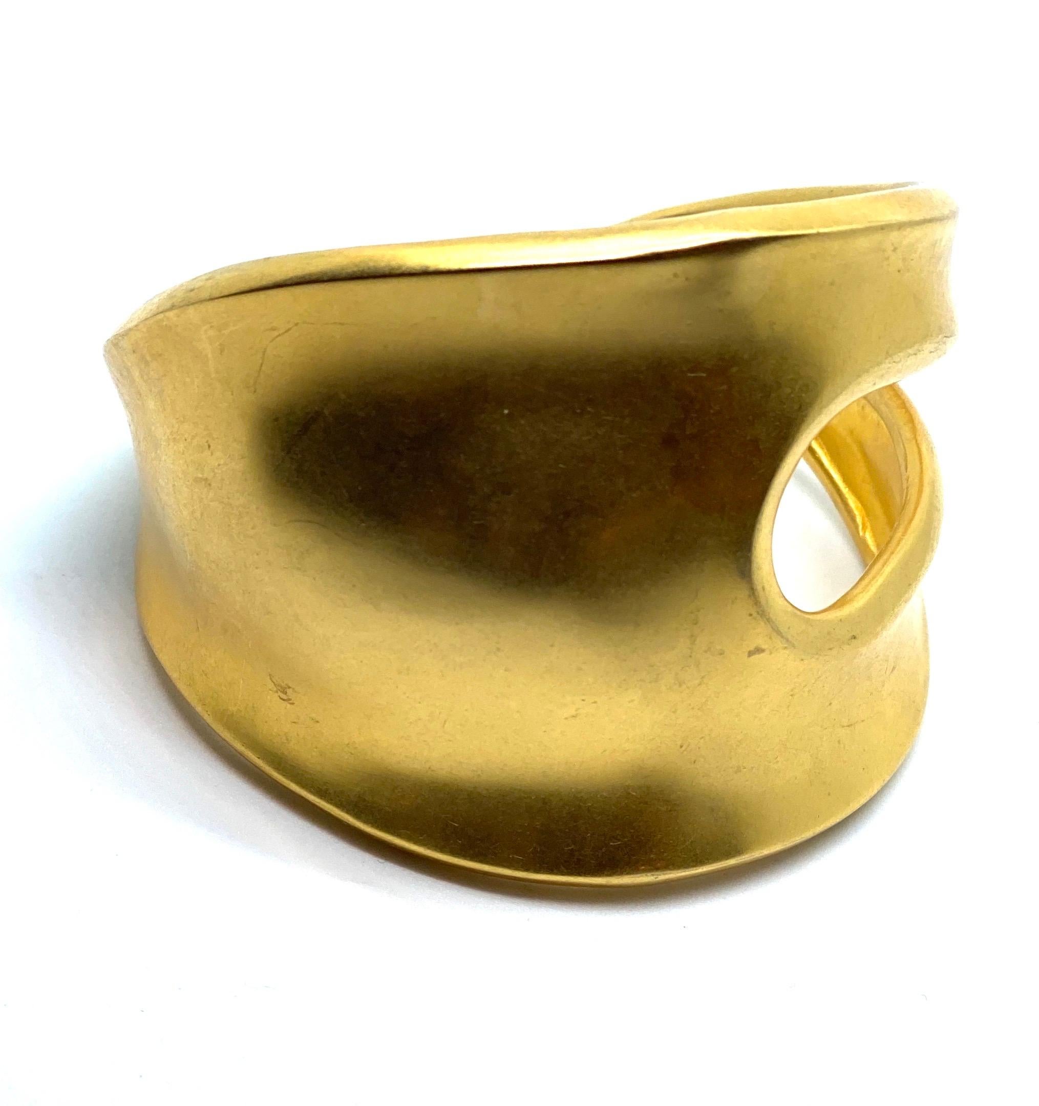 This matte gold plated brass cuff has a dramatic opening in the side of the piece that gives it the name Phantom. The striking positive/negative design is using an eye shaped hole in the face of the cuff that distinguishes this as an iconic Robert