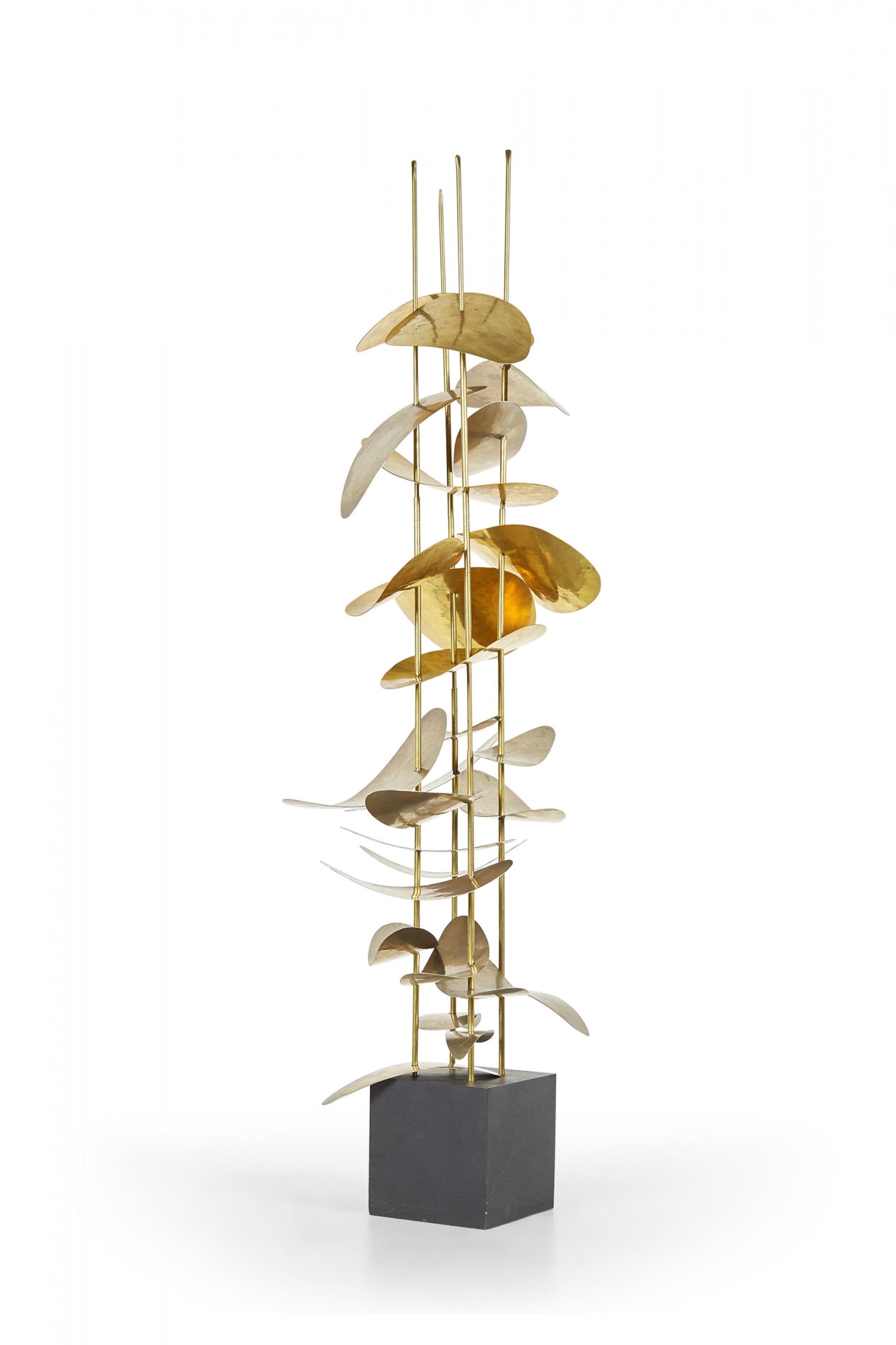 Scultura astratta contemporanea composta da pezzi di nichel e ottone curvi e martellati impilati verticalmente su quattro aste di ottone, montati su una base di legno verniciata di nero, intitolata 