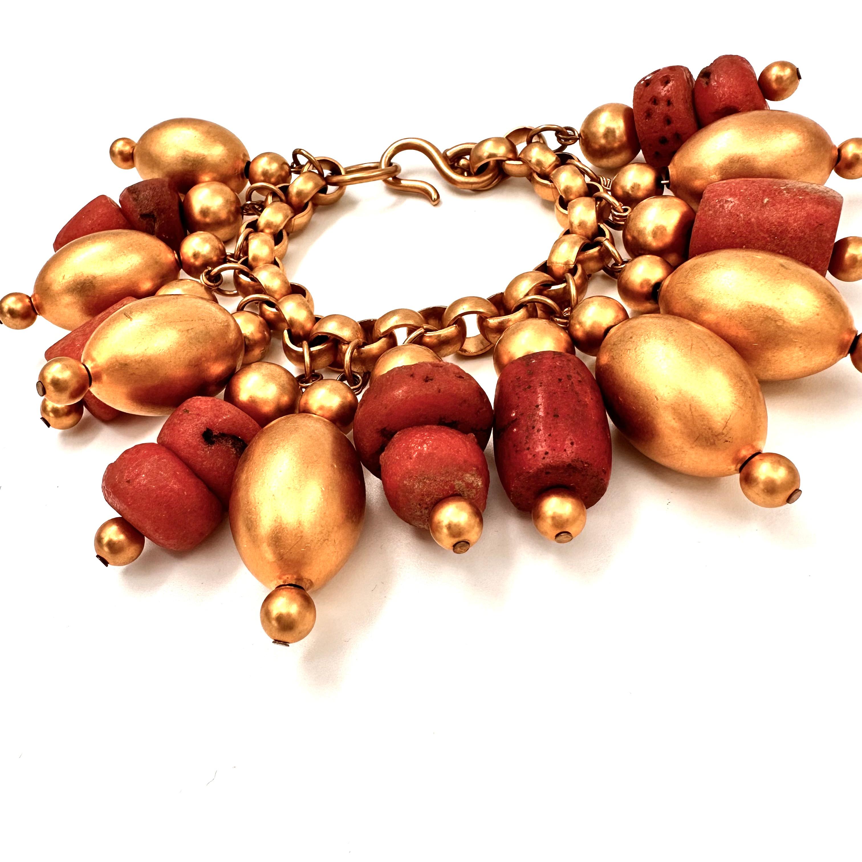 Robert Lee Morris Runway Collection Large Gold Charm Bracelet for Donna Karan, for a resort show in 1987. The oversized Gold plated beads are interspersed with chunks of rounded red African glass beads. Each glass bead is one of a kind and
