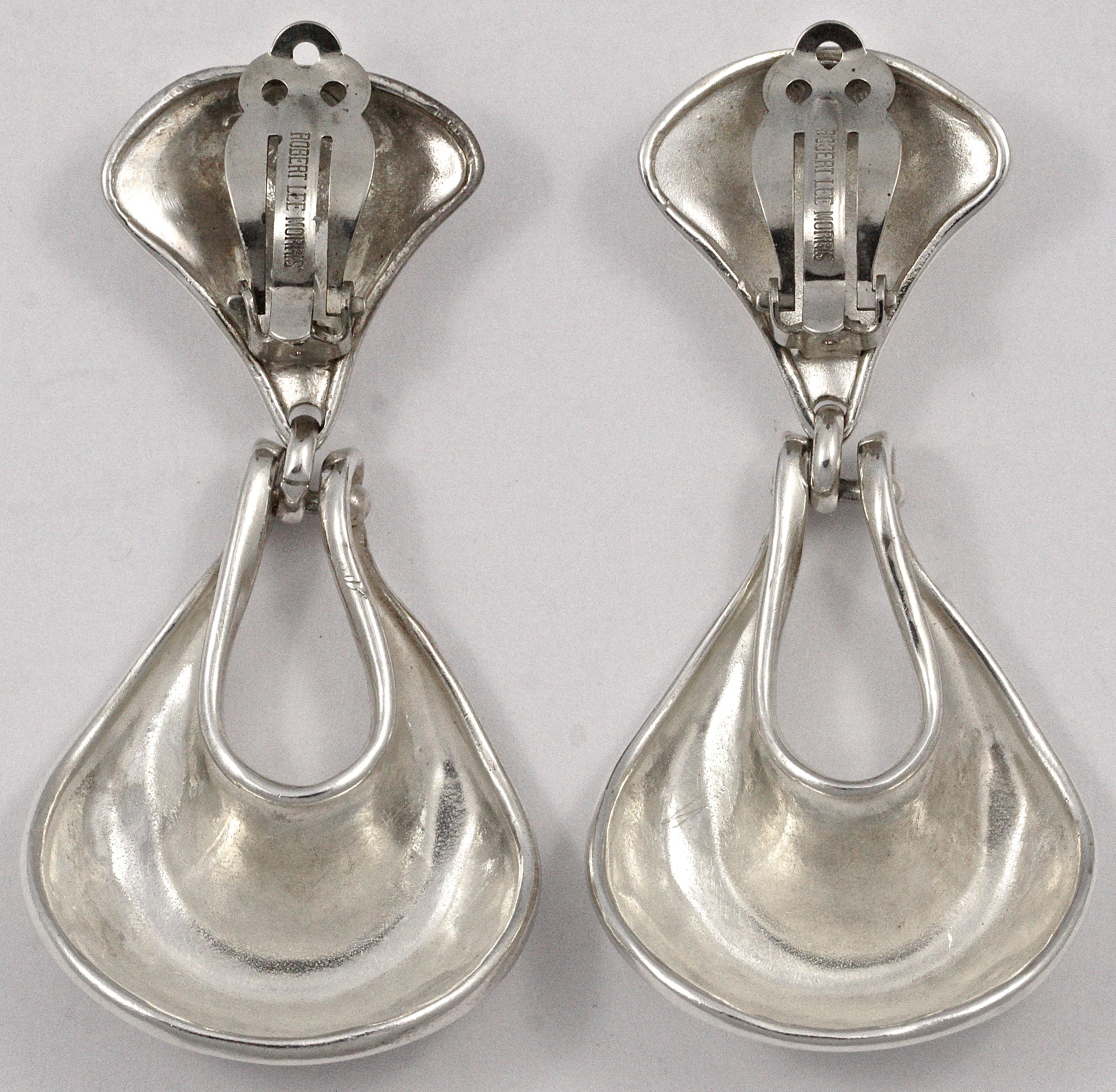 Lovely Robert Lee Morris silver clip on earrings, featuring an organic shaped drop hoop. They test for silver. Measuring drop 6.8cm / 2.67 inches by maximum width 3.2cm / 1.26 inches. They are in very good condition, with surface scratching as