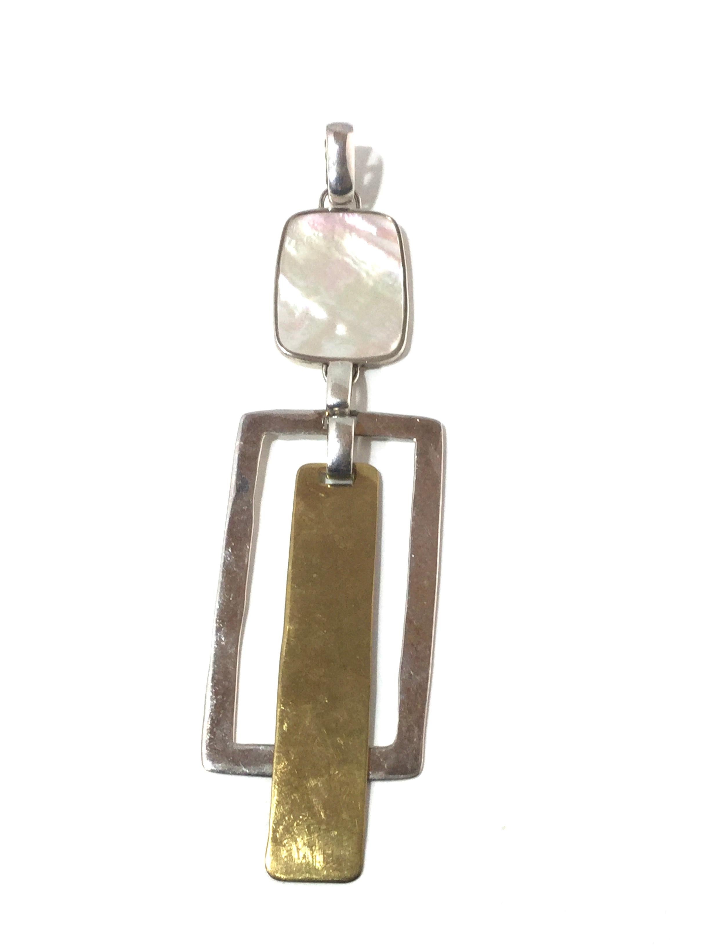 Robert Lee Morris Sterling Silver, Brass and Mother of Pearl Dangle Pendant

Robert Lee Morris Studio modernist pendant, sterling silver, brass & mother of pearl composed of rectangular shapes connected together by links. The bale has a clasp to