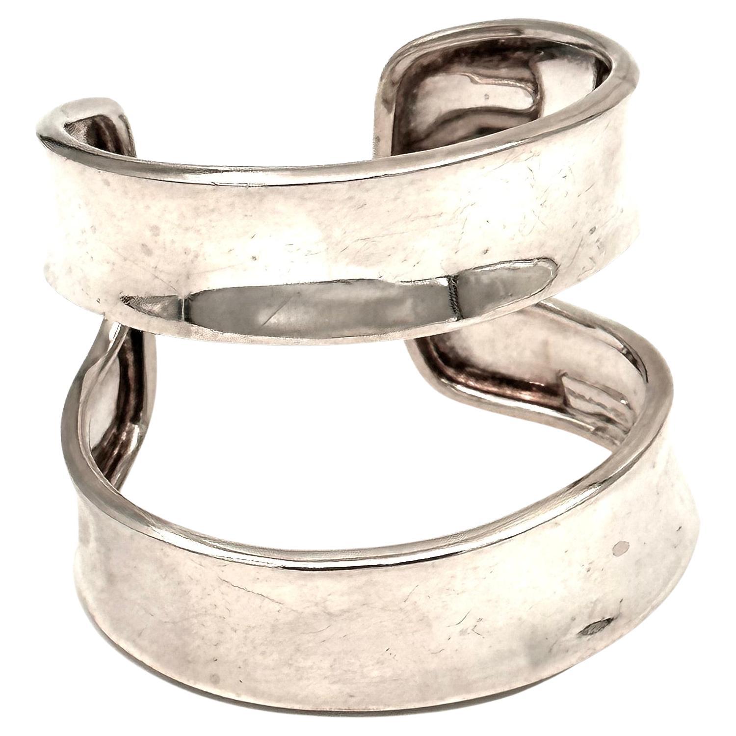 This double band cuff created by hand by Robert Lee Morris was made for a 2003 Donna Karan fall runway show. Robert Lee Morris is well known for his bold, graphic runway pieces, and this spare but bold silver cuff is a prize for the silver cuff