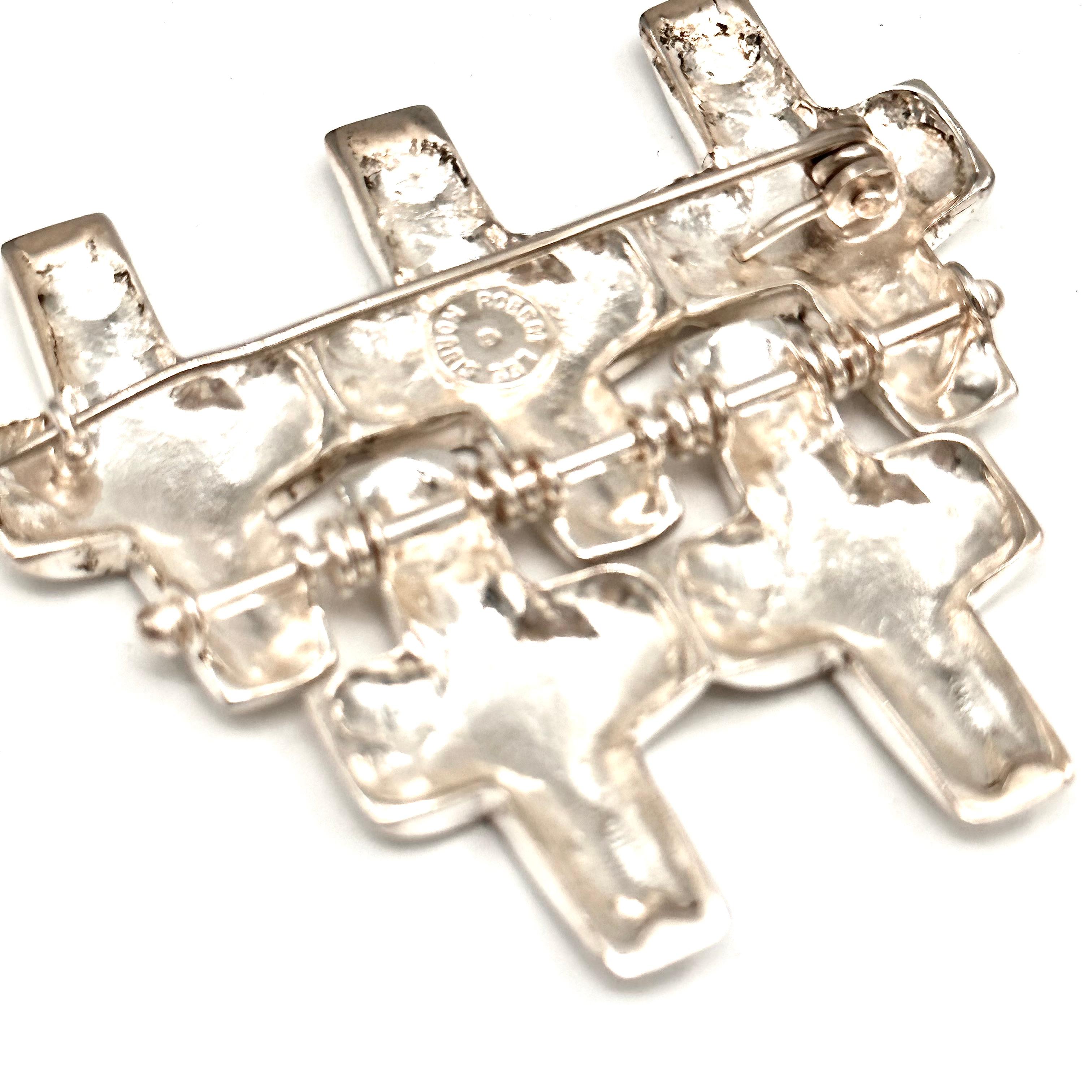 This is a large, flexible, moveable kinetic sterling silver brooch by Robert Lee Morris, constructed in the late 1980's as part of his mens collection. The bottom two crosses swing easily from the top three crosses. There is a sculptural dimension