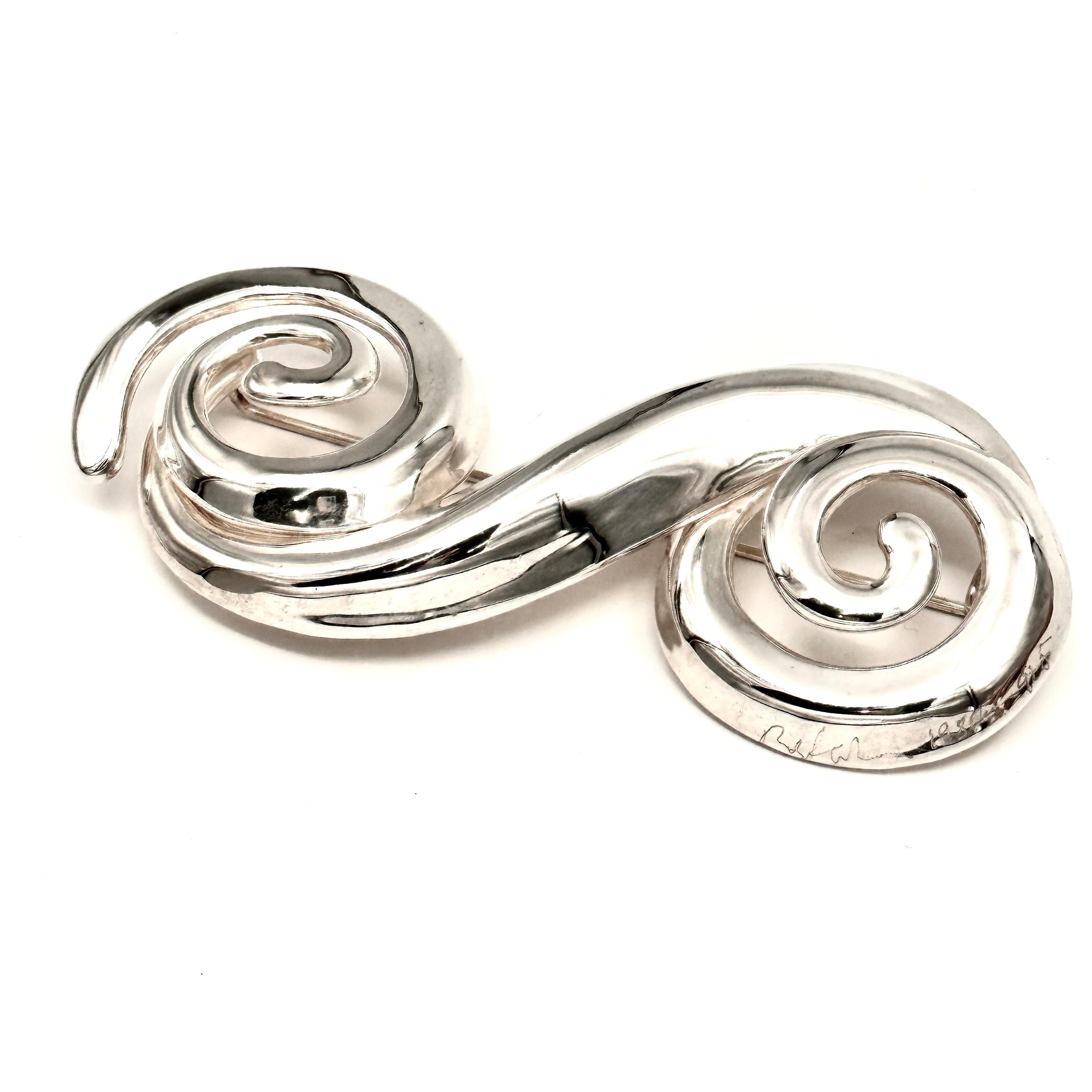 What a fun and dramatic piece this one is! Very large and important, a true statement of glamour and high fashion, this brooch is composed of two spirals that are joined by a sweeping curvilinear form, very dimensional and sculptural. Big scale was