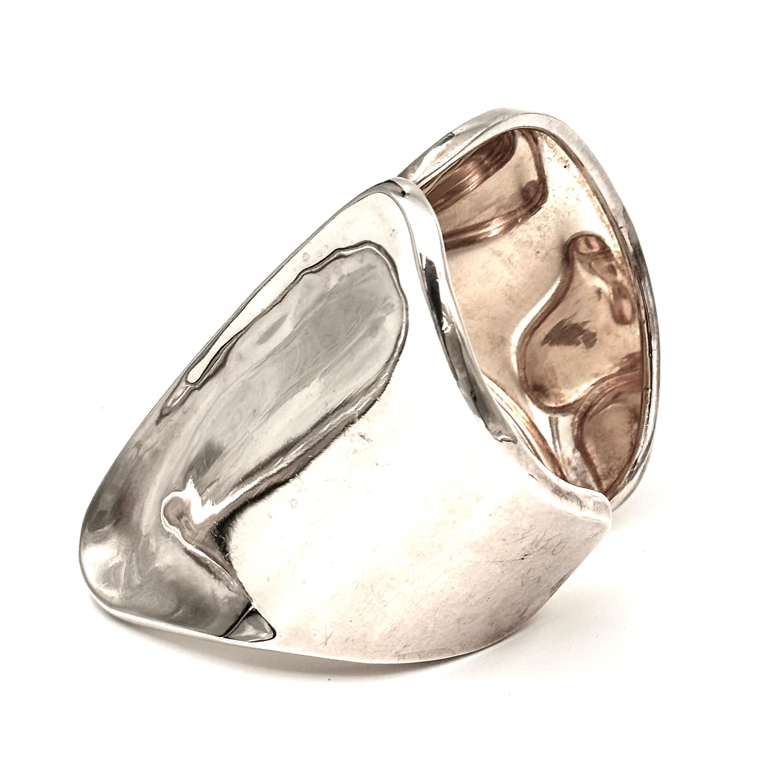 The soft abstract design of this dramatic cuff, is of two wings, gently meeting, with a thick edge of silver as the long curved vertical line in the center. Gleaming bright silver plated brass, this cuff is gorgeous bold and comfortable to wear. One