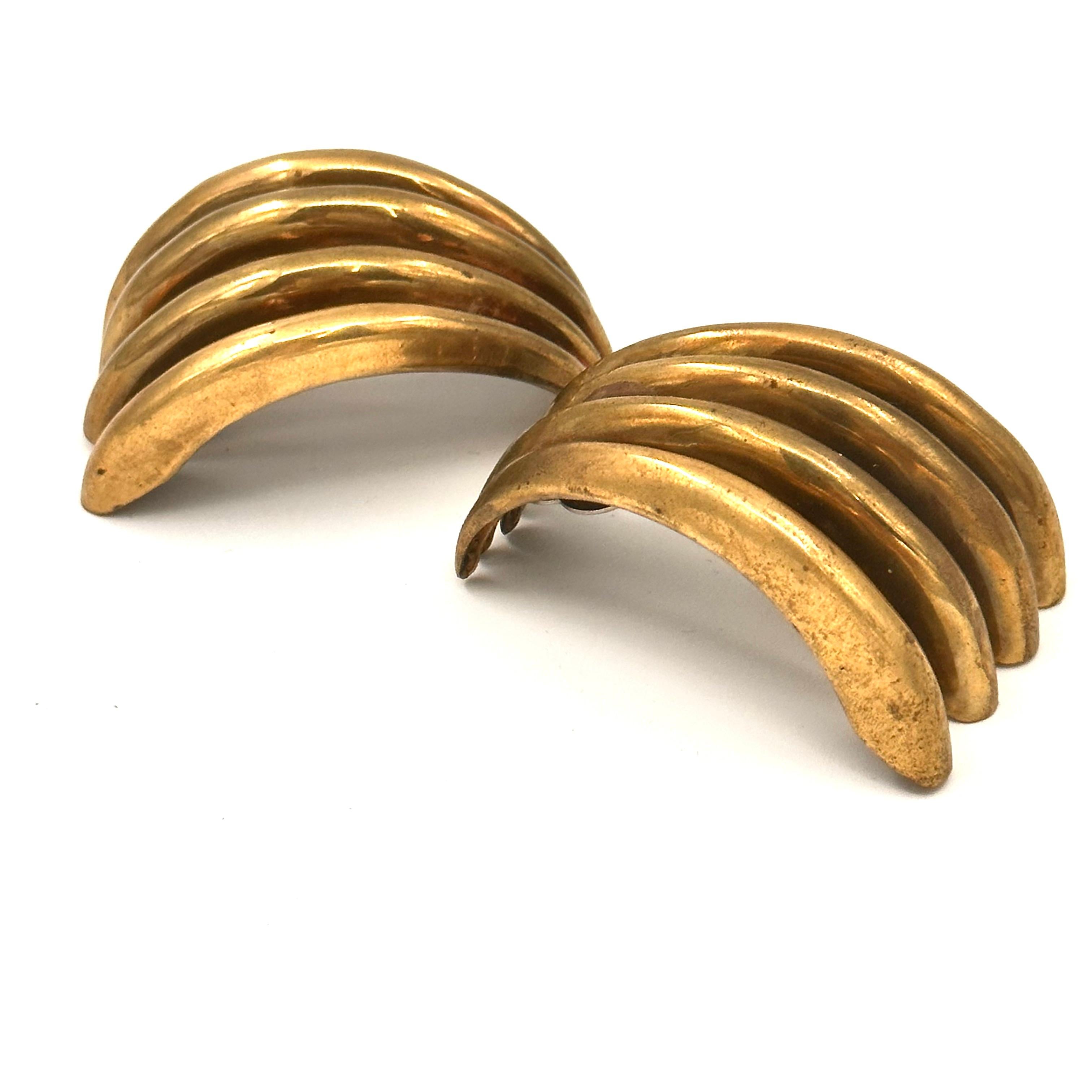 This bold and sculptural clip on earring is an example of the big scale jewelry Robert Lee Morris and Donna Karan created for furnished the runway. These are a warm burnished brass, hollow rib forms so still light enough to wear. Bold Dynamic