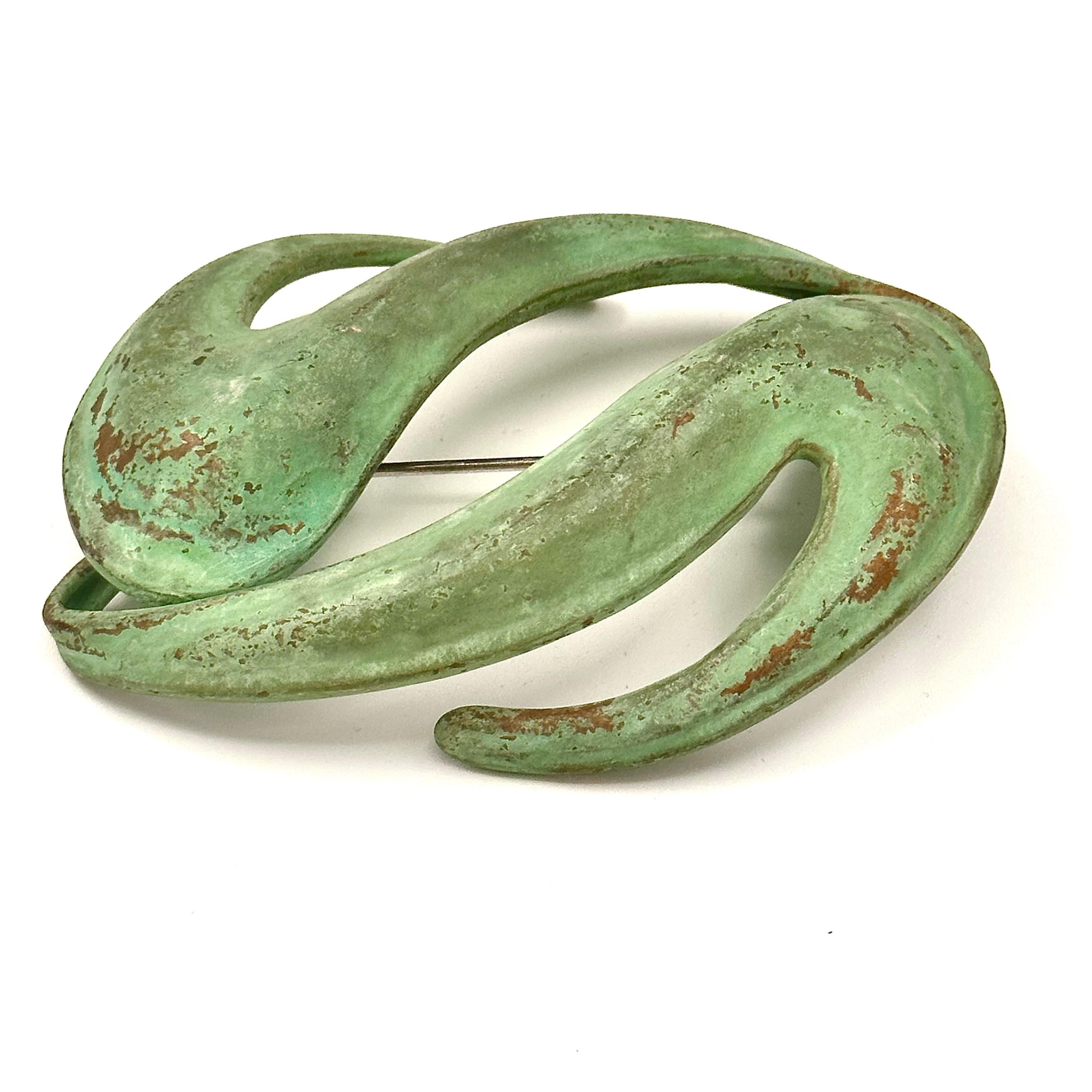 The scale and color and form of this brooch is iconic Robert Lee Morris fashion/art jewelry. First is the voluptuous shapes that are crafted into a flowing, undulating sculpture that is then Colored with a Verdigris oxidation, which gives it a