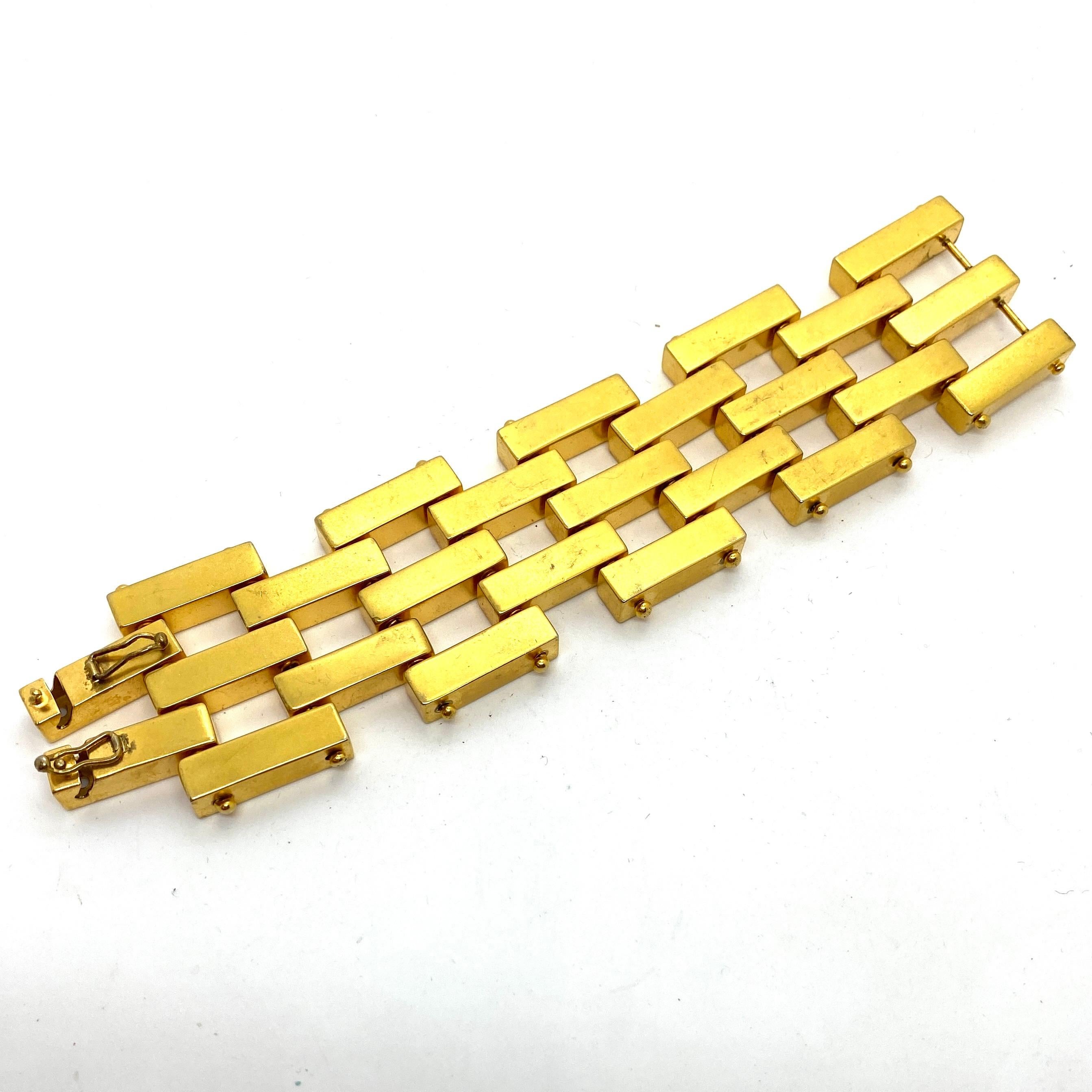 Robert Lee Morris makes sculptural art/fashion jewelry that is both sensually organic as well as architectural and engineered into liquid geometry. This is a classic 2x3 row Bar bracelet, matte gold plated brass and composed of individual hollow