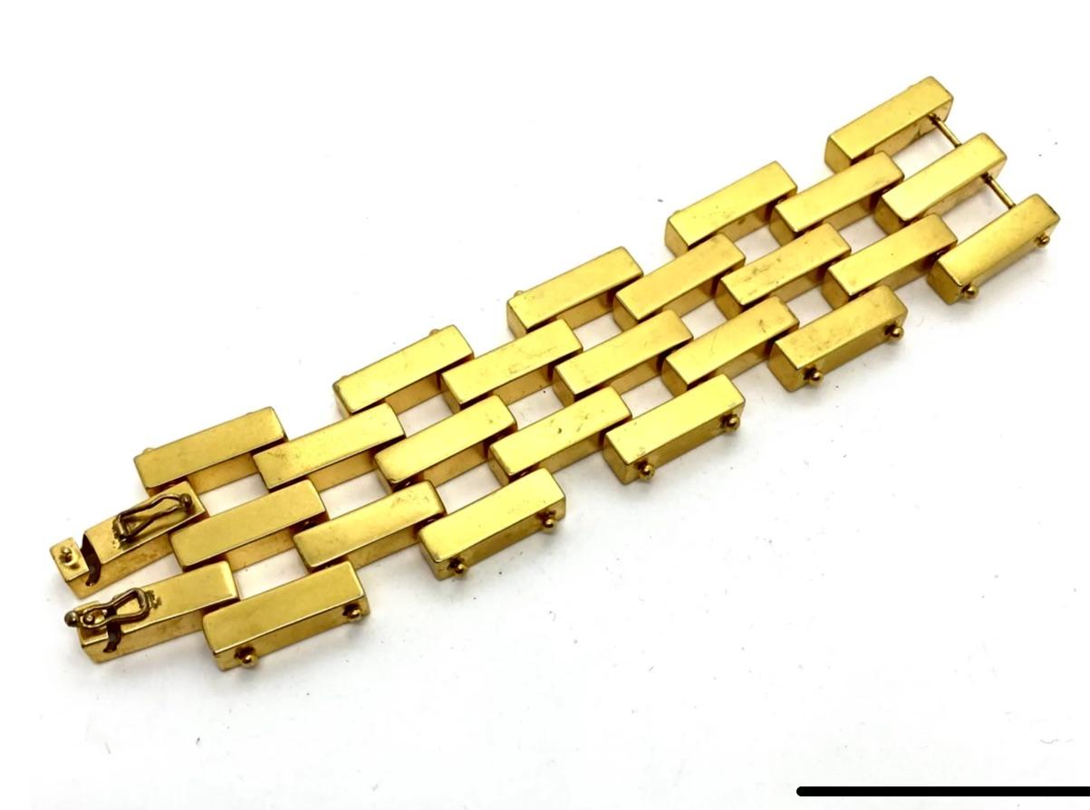Robert Lee Morris makes sculptural art/fashion jewelry that is both sensually organic as well as architectural and engineered into liquid geometry. This is a classic 2x3 row Bar bracelet, shiny gold plated brass, composed of individual hollow