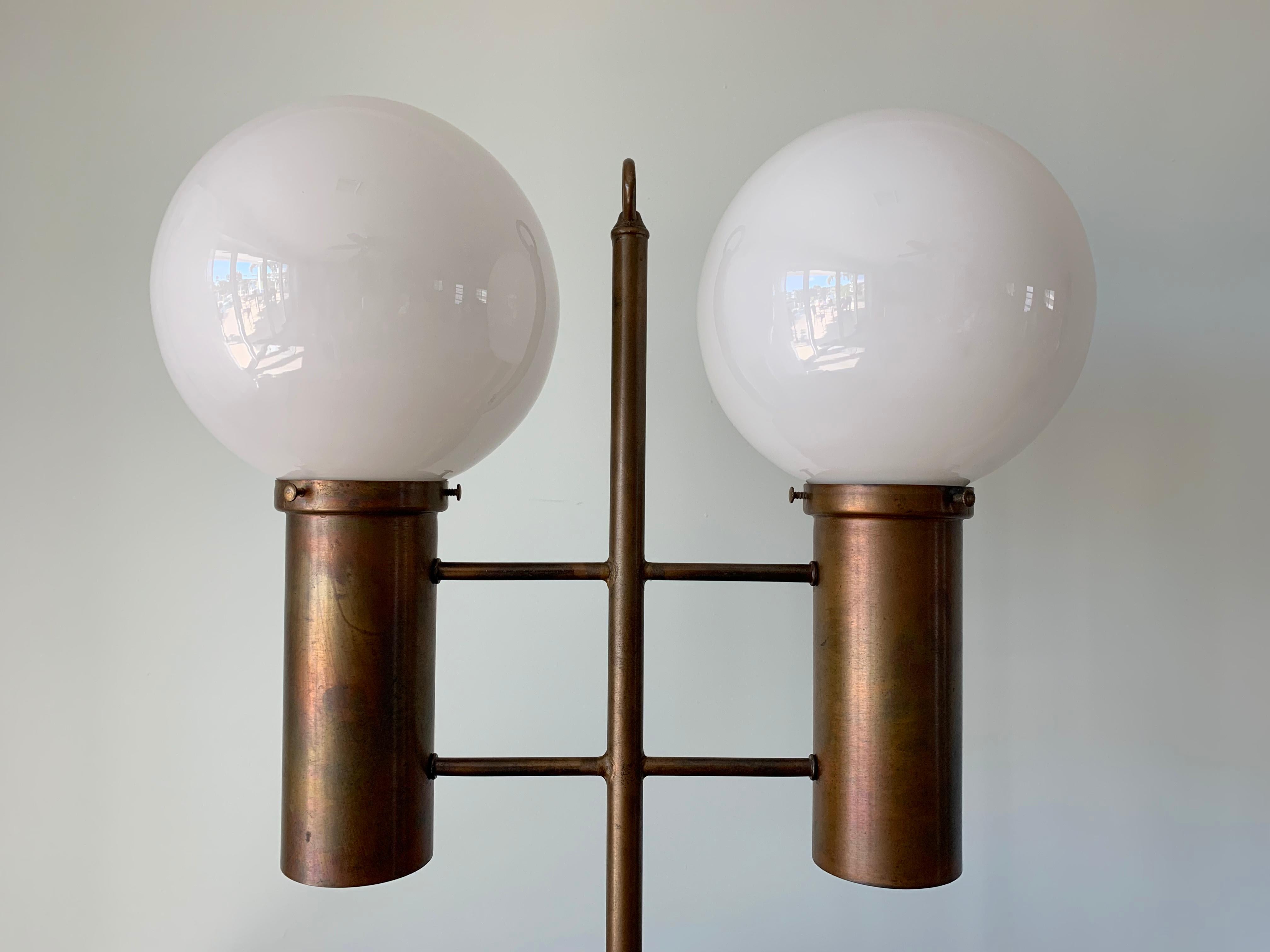 Große Tischleuchte von Robert Long.
Die Lampe ist aus massivem Messing und Opalglas gefertigt.
Sie verfügt über 2 Steckdosen für die Glaskugeln, 2 Steckdosen für die Unterseite der Messingzylinder (Umgebungslicht) und einen 3-Wege-Schalter (oben,