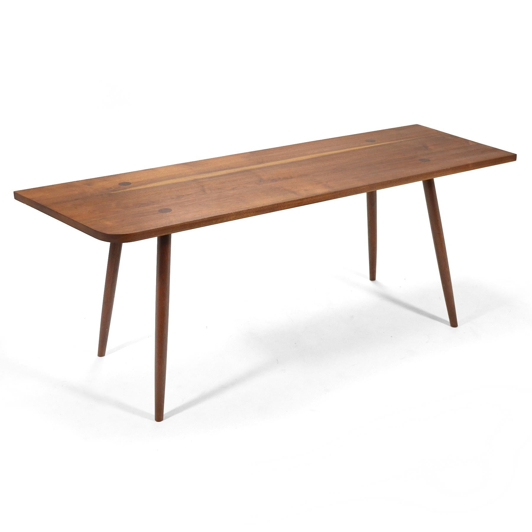 This beautiful table crafted of black walnut was designed and handcrafted in 1961 by Robert Lovett. It is expertly built with through-tenon legs and subtle details like the single radiused corner and angled edge. It is beautifully scaled allowing it