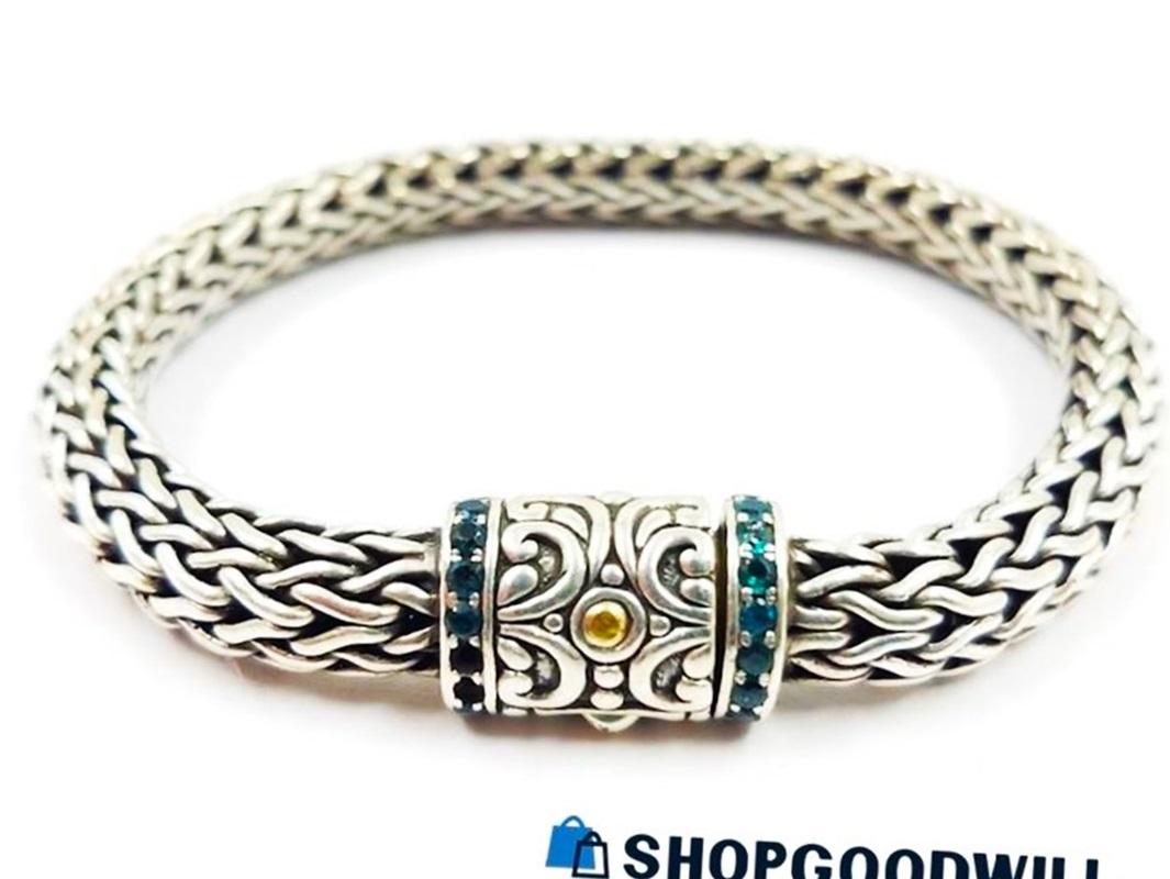 This is a pre-owned Robert Manse Bali Bracelet that has been discontinued.  It's pre-owned and in excellent condition.  It is Sterling Silver with 18k Yellow Gold enhancements.  It is 8 inches long and 8 mm wide.  The closure has 8 diamond cut green