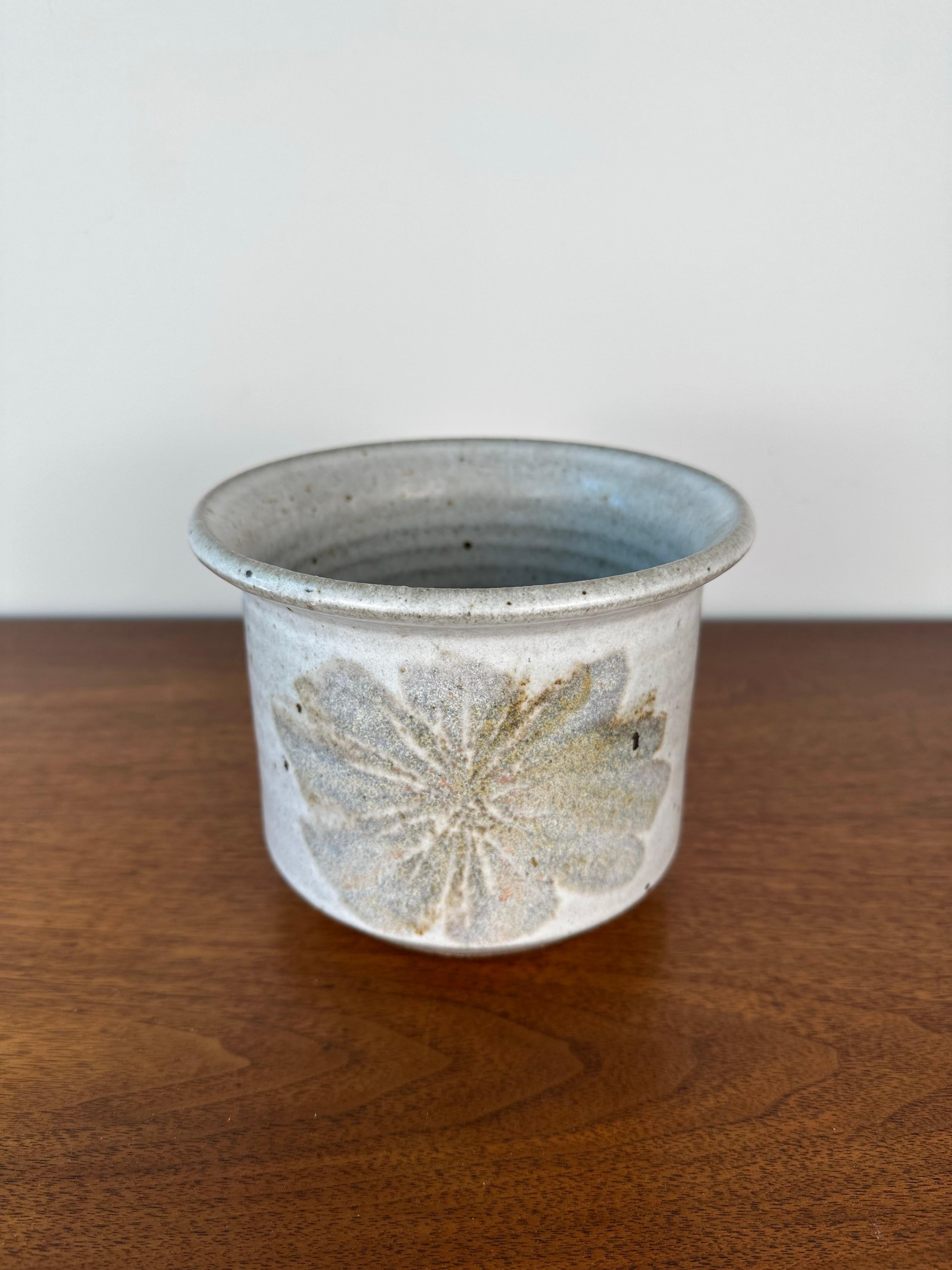 Ce superbe récipient à motif floral de Robert Maxwell & David Cressey incarne l'esthétique terreuse et organique qui définit Earthgender Ceramics. Fabriquée en Californie en 1977, cette pièce en grès émaillé présente un motif floral magnifiquement