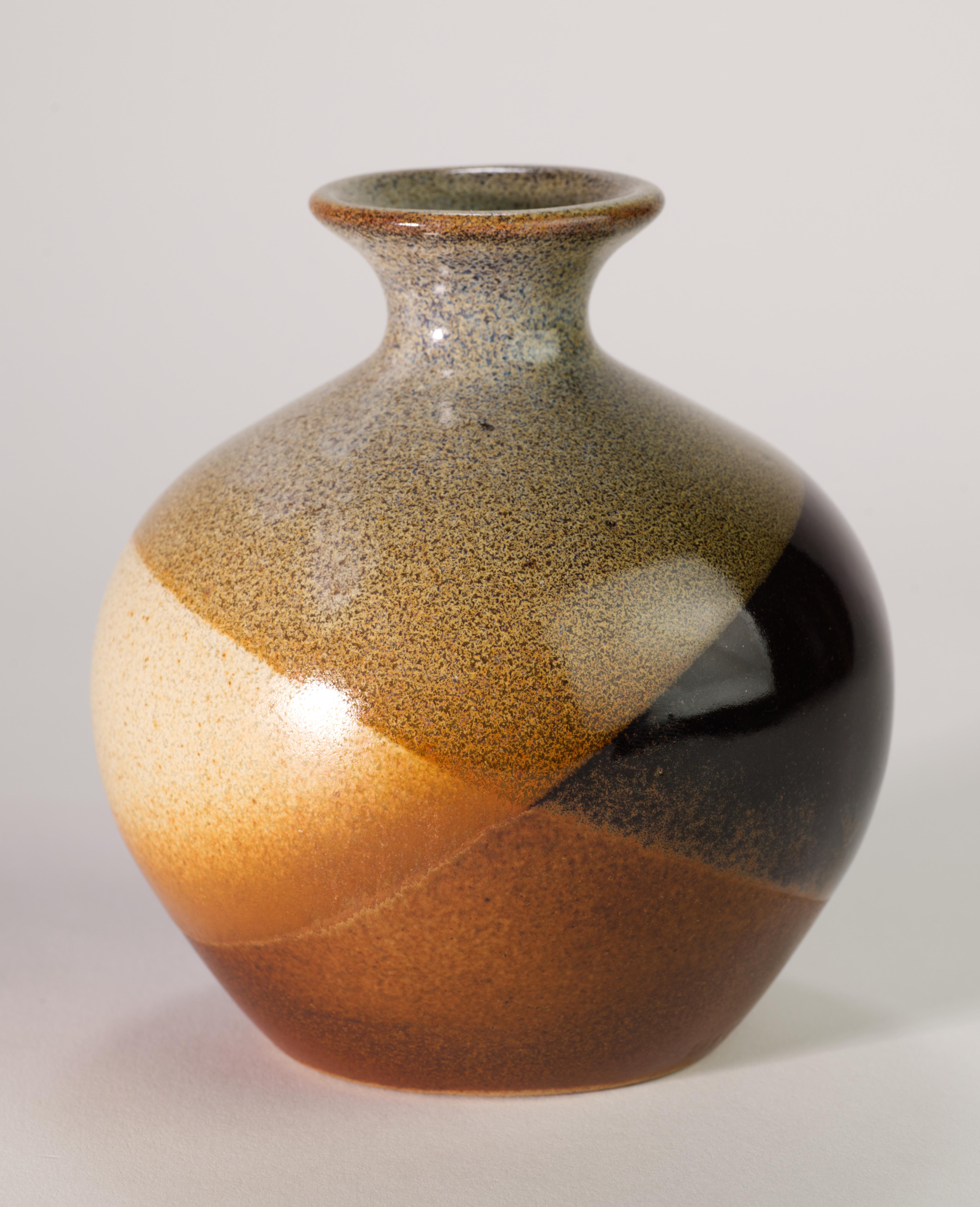  Il vaso moderno e sorprendente con motivo a cerchi sovrapposti è stato creato da Robert Maxwell per Pottery Craft USA utilizzando la sua innovativa tecnica di smaltatura con lavaggi astratti e strati di marroni e grigi che sono diventati una firma.