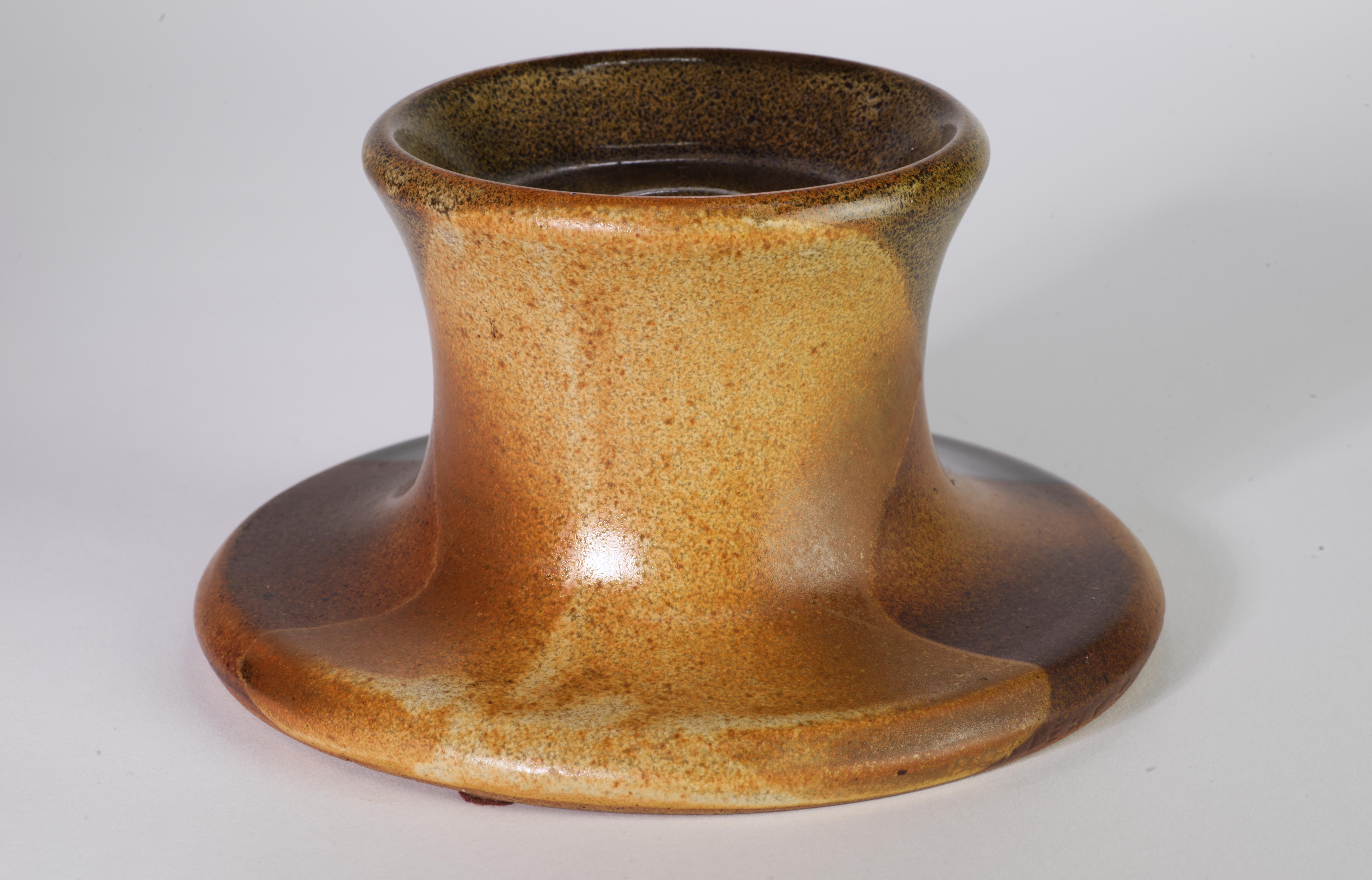  Il candeliere moderno e sorprendente con il motivo dei cerchi sovrapposti è stato creato da Robert Maxwell per Pottery Craft USA utilizzando la sua innovativa tecnica di smaltatura con lavaggi astratti e strati di marroni e grigi che è diventata