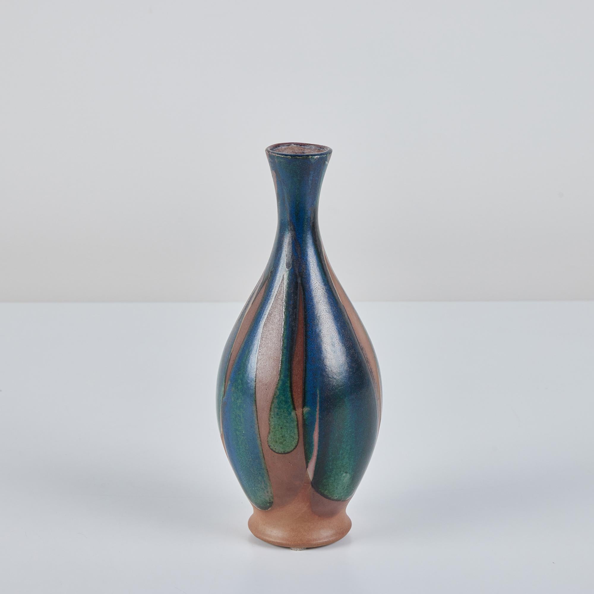 Vase à bourgeons en grès, jeté à la main par le céramiste californien Robert Maxwell. Le vase est recouvert d'une glaçure bleu-vert en goutte d'eau sur un récipient en grès brun chaud.
Labellisé - Robert Maxwell Stoneware Handcrafted