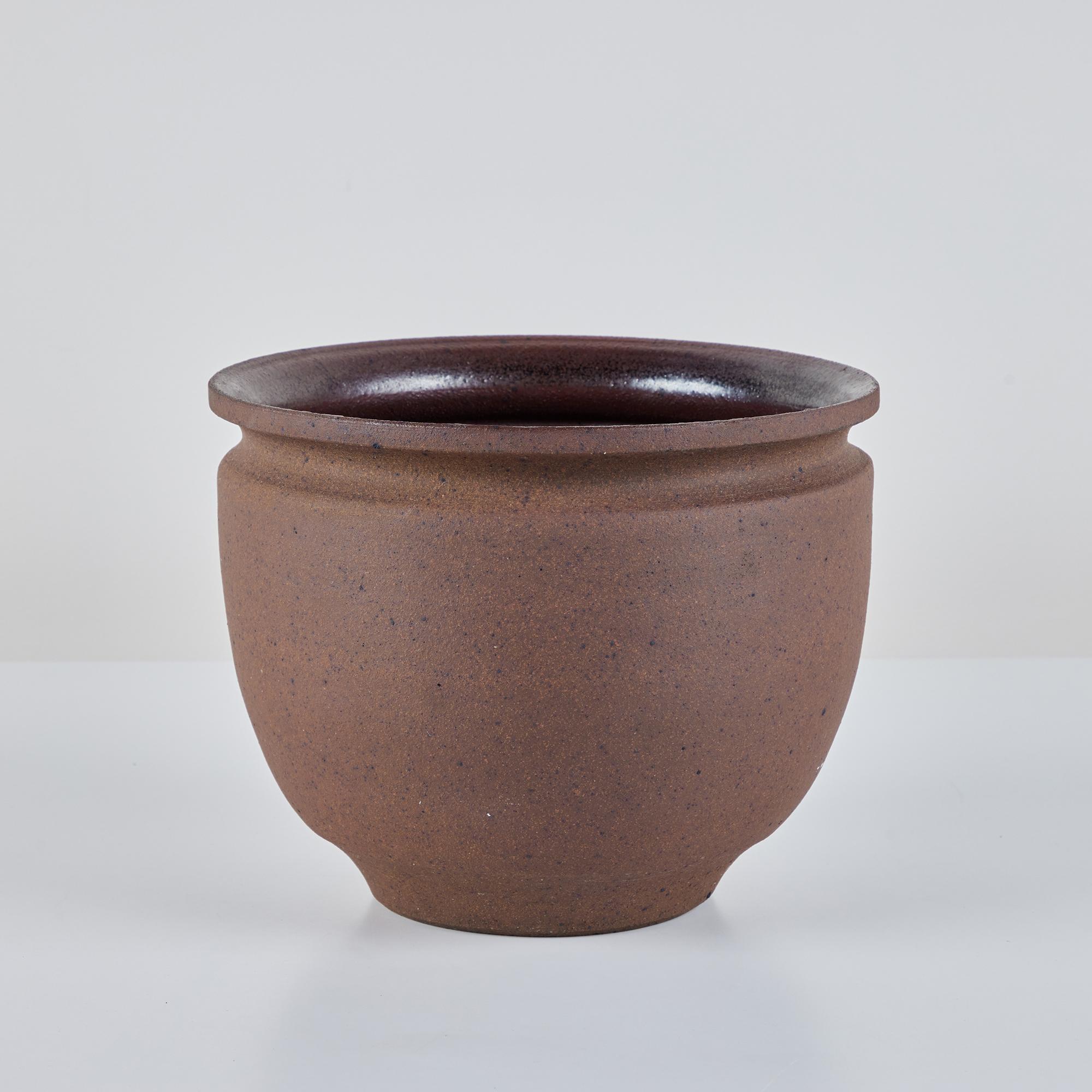 A hand thrown stoneware bowl planter from California ceramicist Robert Maxwell. The planter has a rounded lip and speckled stoneware exterior. The interior is glazed in a warm brown speckle.

Dimensions
11” diameter x 8.75”