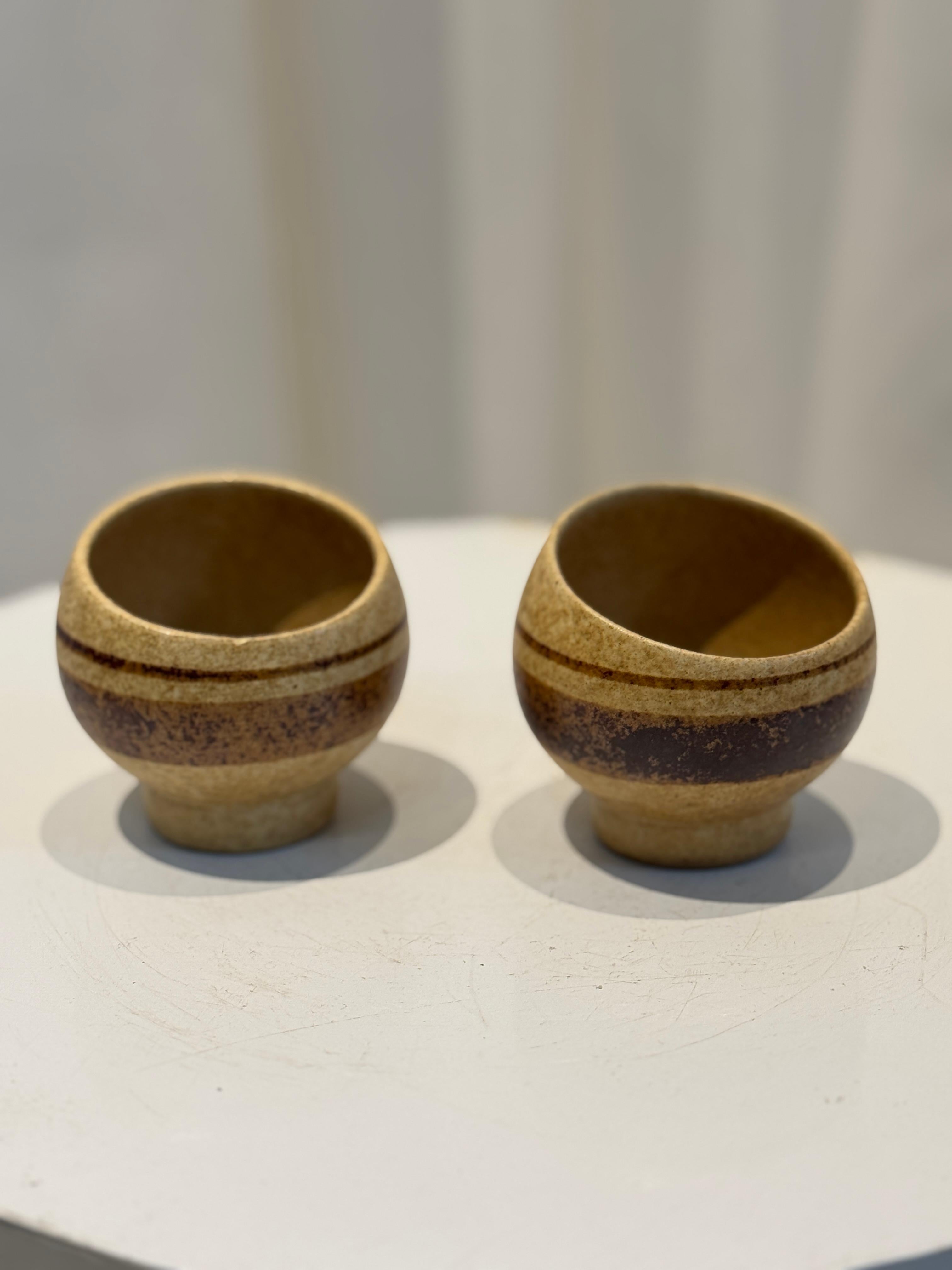 Eleva la tua collezione con questa squisita coppia di tazze in Studio Pottery realizzate a mano dal famoso artista ceramista di metà secolo Robert Maxwell. Conosciuto per le sue forme organiche e gli smalti terrosi, il lavoro di Maxwell incarna