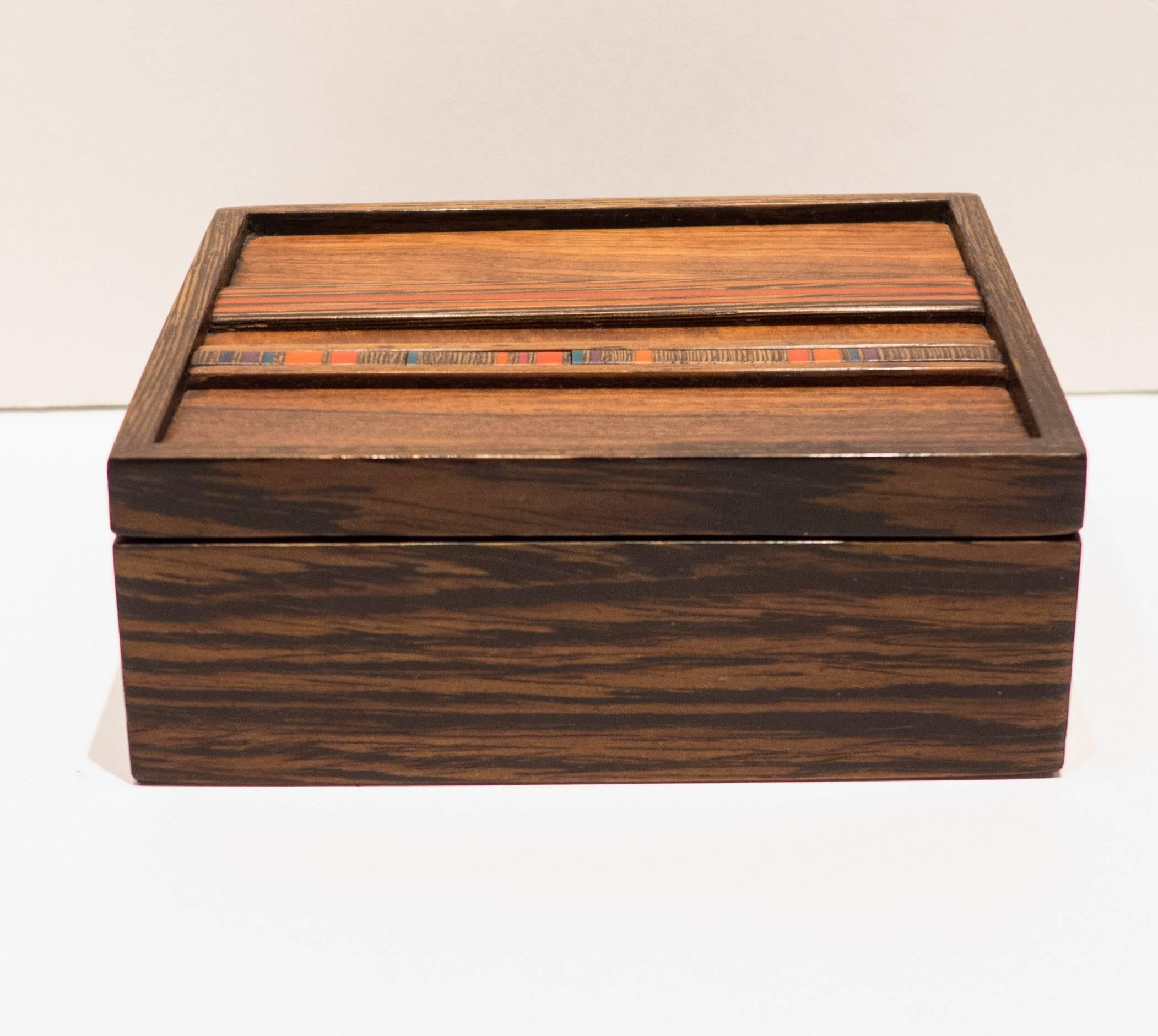 Wooden lidded box with two bands of multi-color resin inlay. By San Francisco Bay artisan Robert McKeown (1931-1989). A graduate of the California College of Arts & Crafts, McKeown was a color theorist and woodworker who won acclaim for his