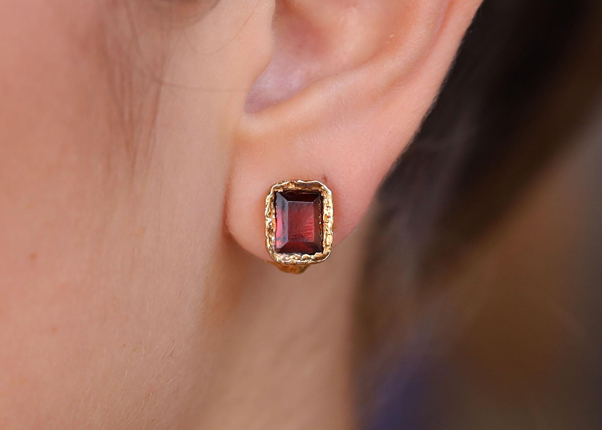 Own a piece of history with this pair of glorious garnet stud earrings from the estate of Hollywood icon Robert Mitchum. Worn regularly by his long time wife Diana, the yellow gold brutalist style features a pair of rich burgundy red garnets in an